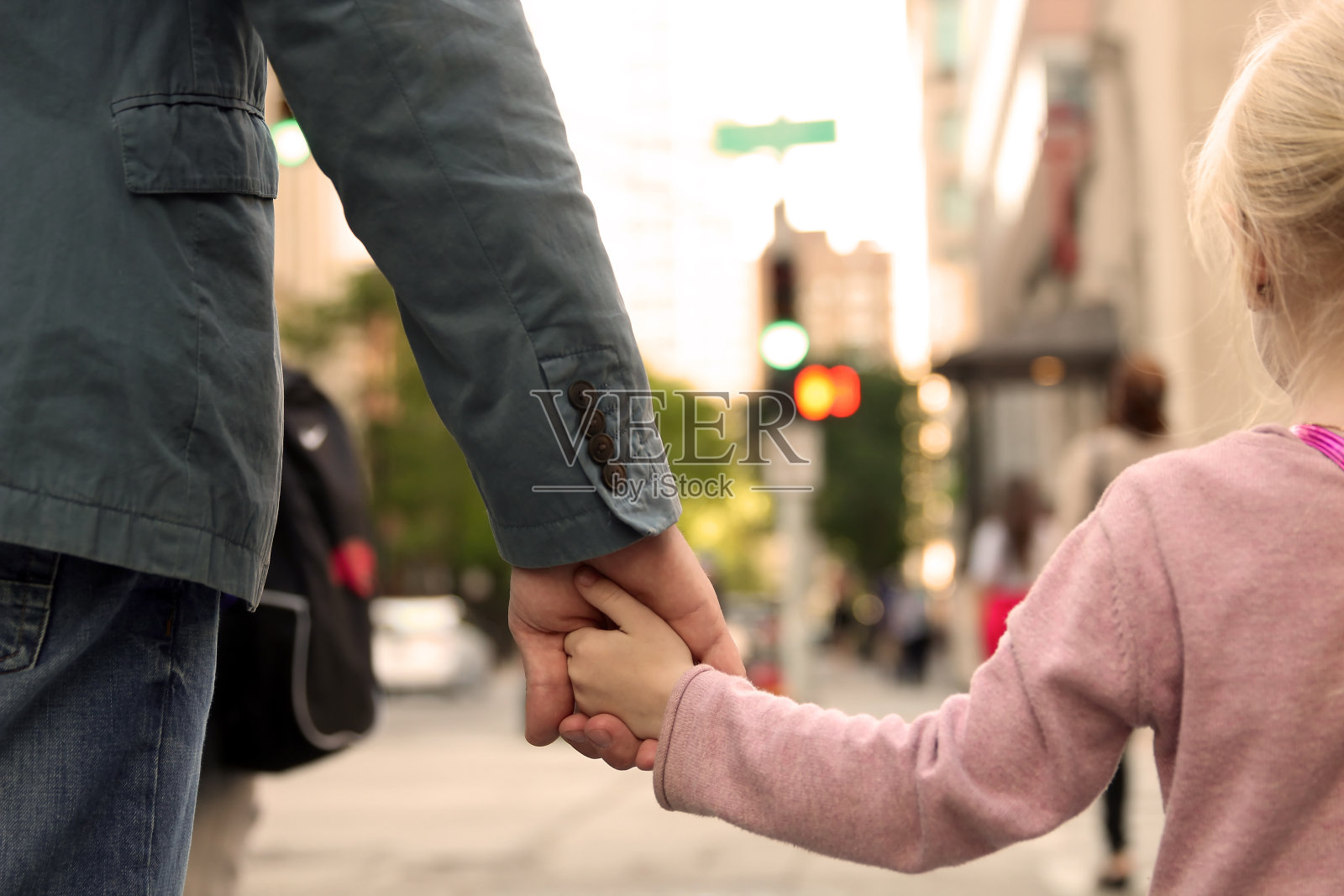 父亲把女儿/孩子的手放在红绿灯后面照片摄影图片