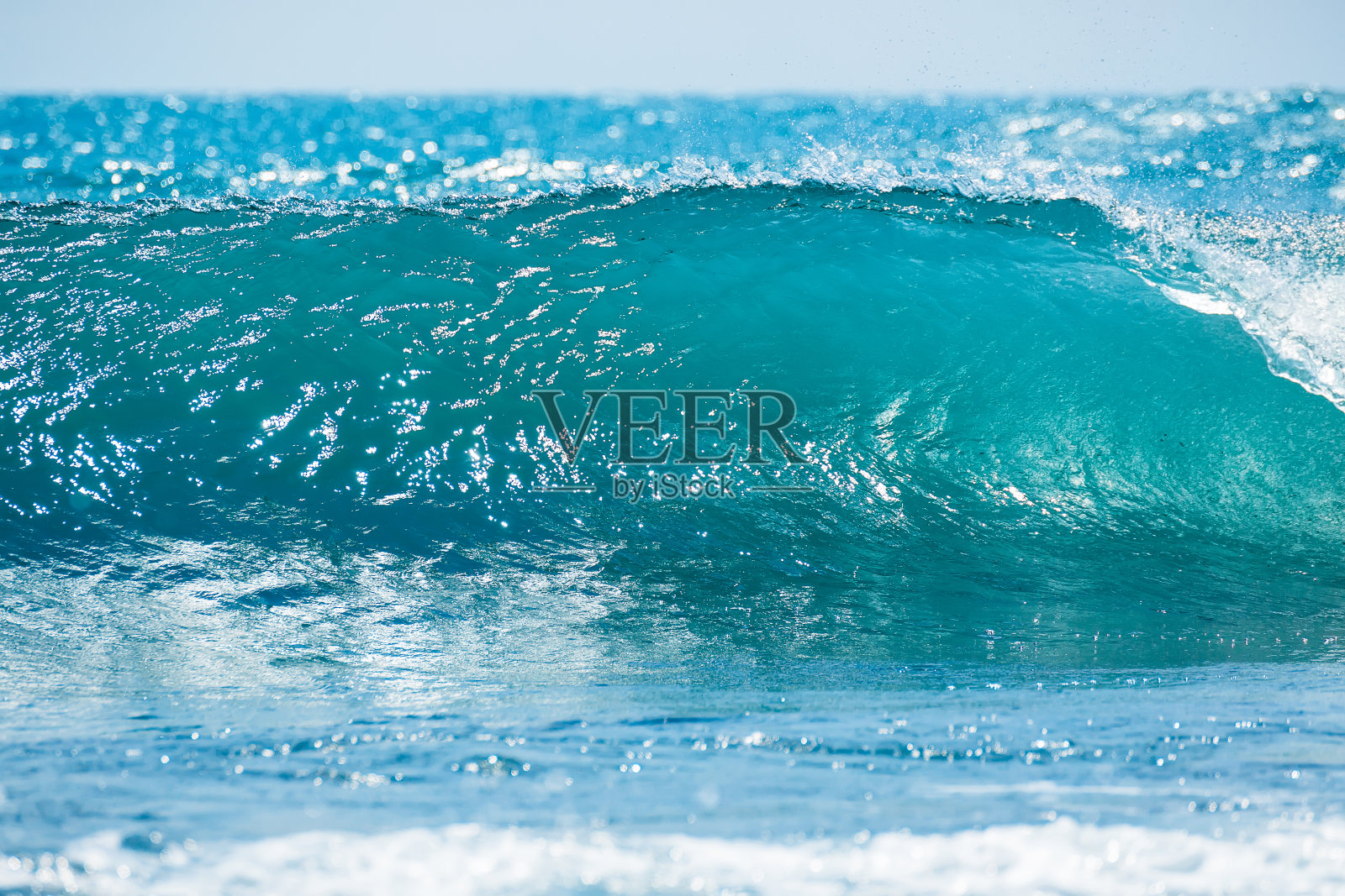 热带海洋中的蓝色波浪。浪桶哗哗，水清阳光照照片摄影图片