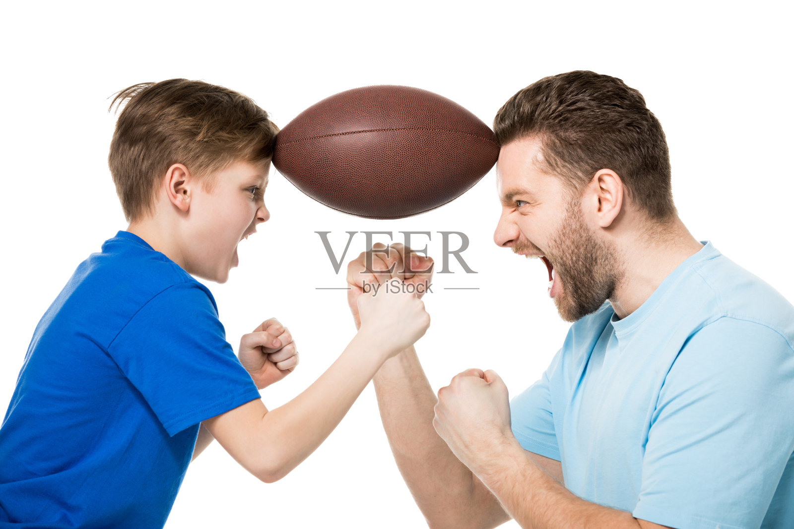 侧面的父亲与儿子尖叫和抱着橄榄球之间的脸孤立在白色照片摄影图片
