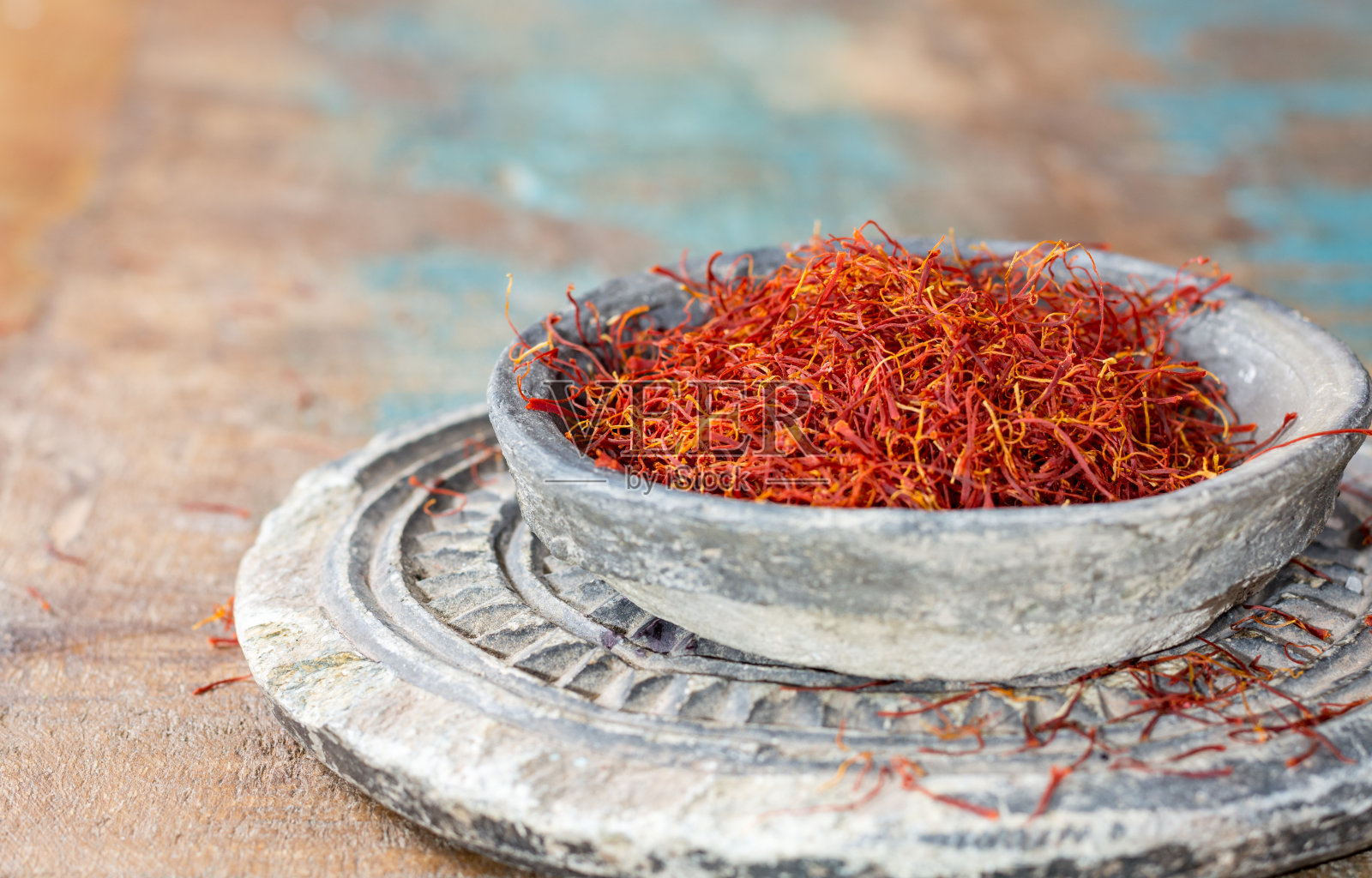 干燥的有机红藏红花香料在一个石头碗在木制的背景照片摄影图片