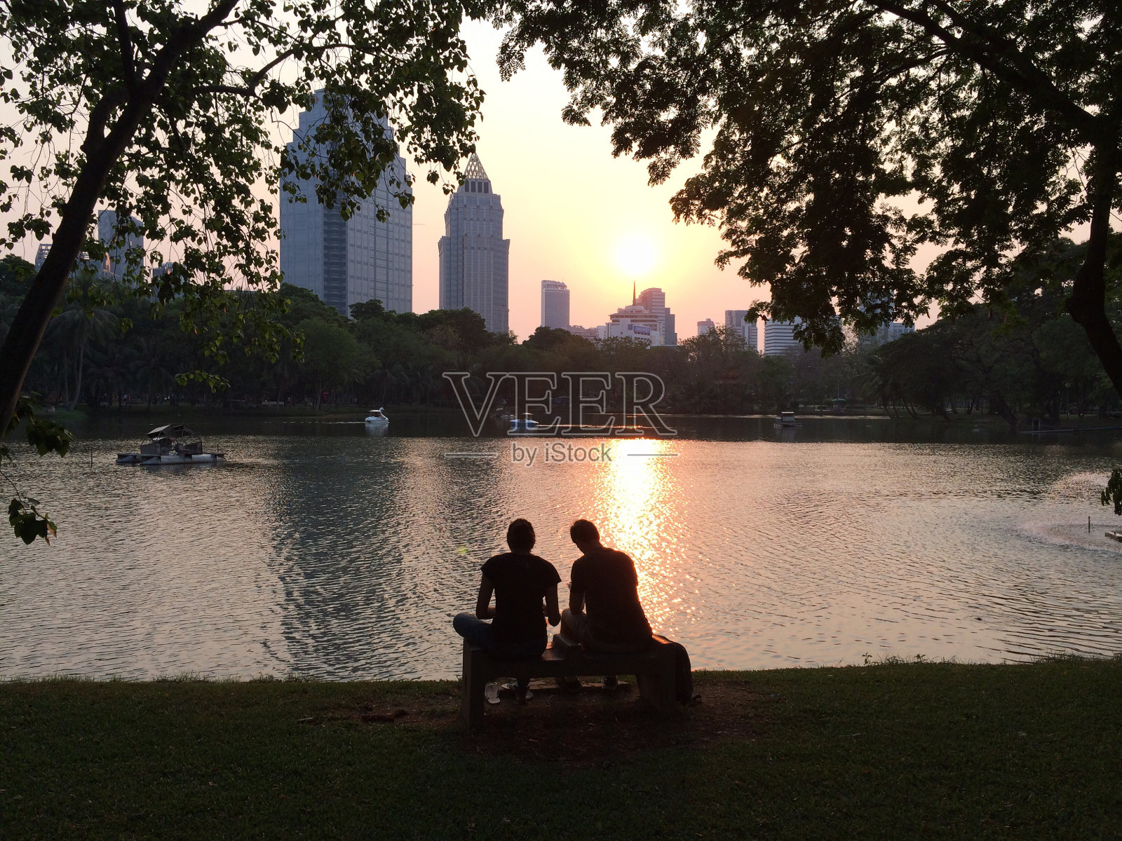 剪影情侣约会在公园看日落照片摄影图片