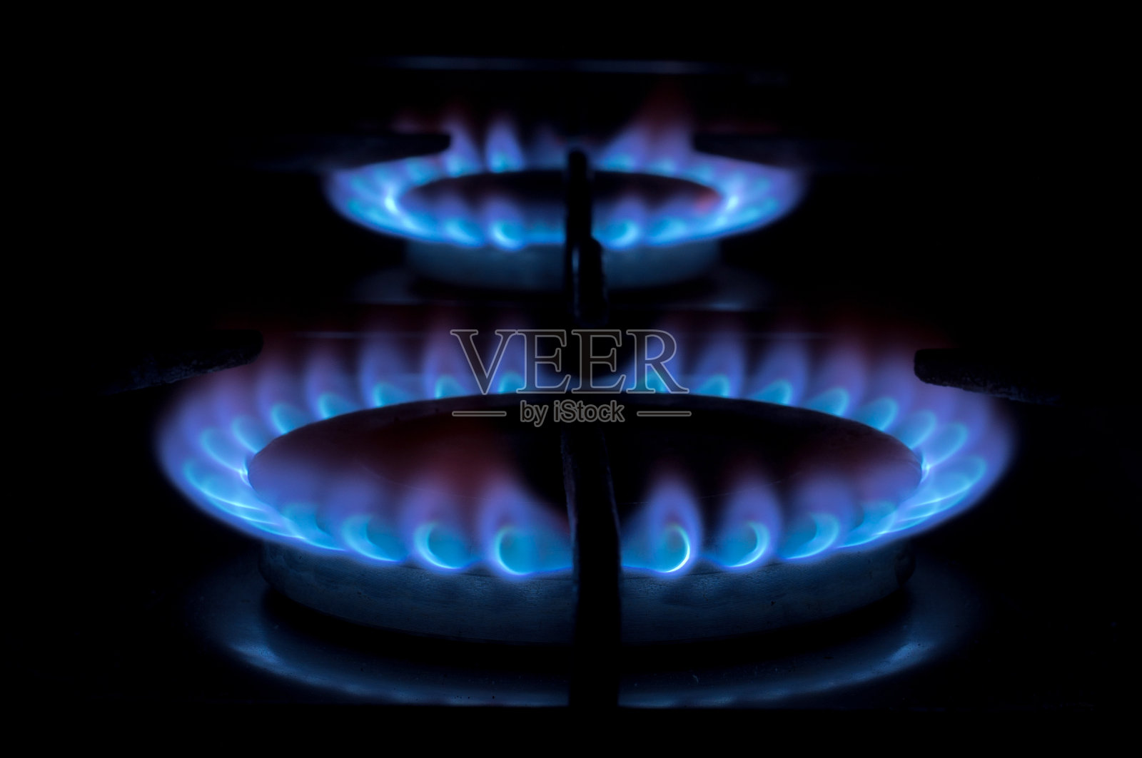 炉子上的煤气炉。瓦斯火在黑色背景。注意靠近的燃烧器照片摄影图片