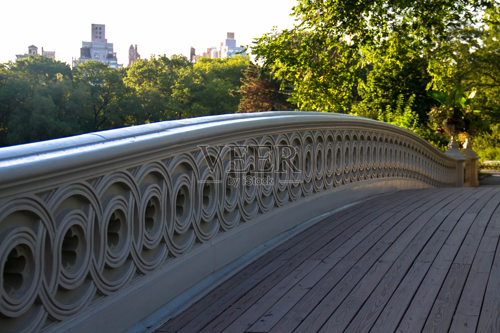 中央公园弓桥的木制通道和曼哈顿的建筑物照片摄影图片