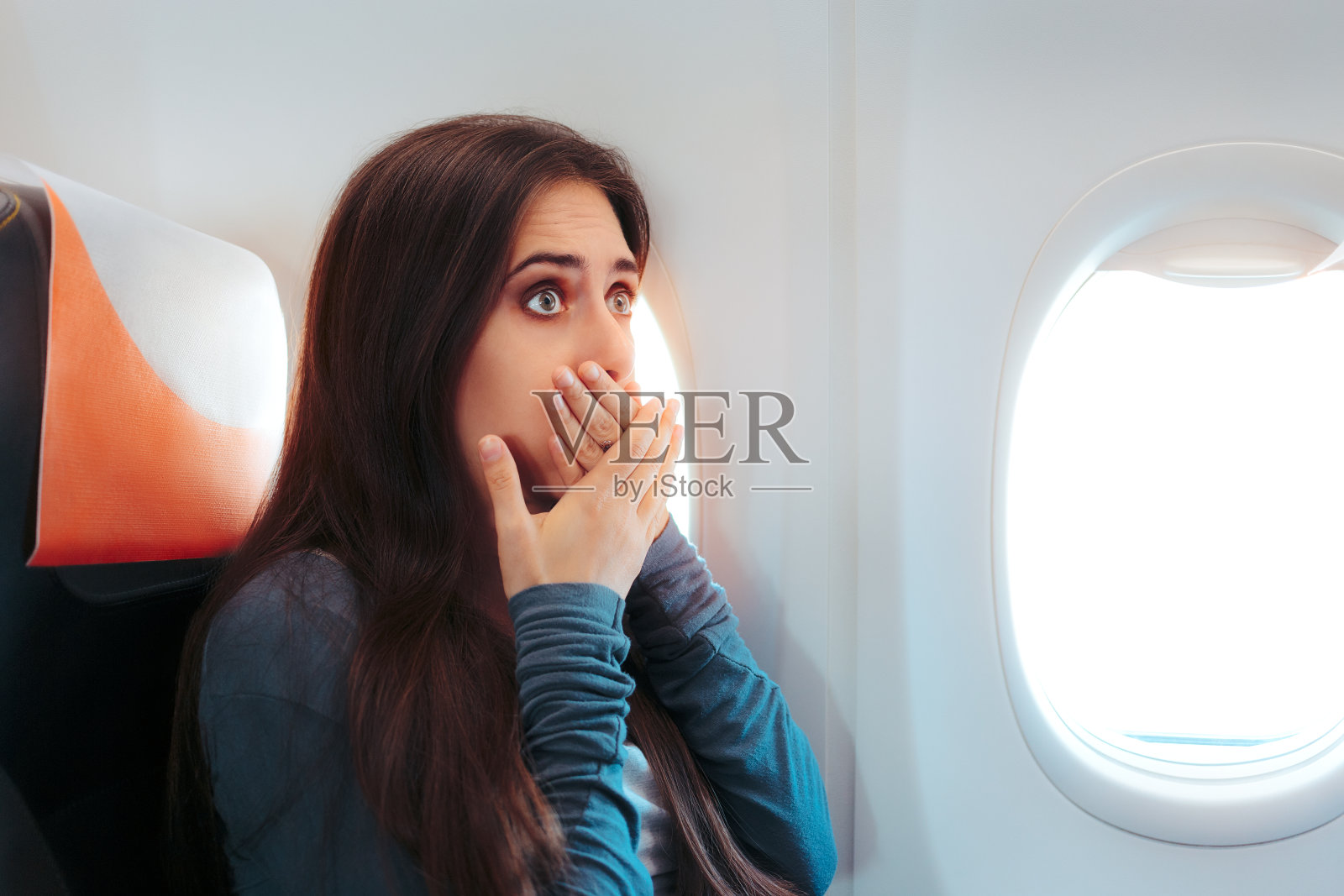 坐在飞机窗边的女人感觉不舒服照片摄影图片