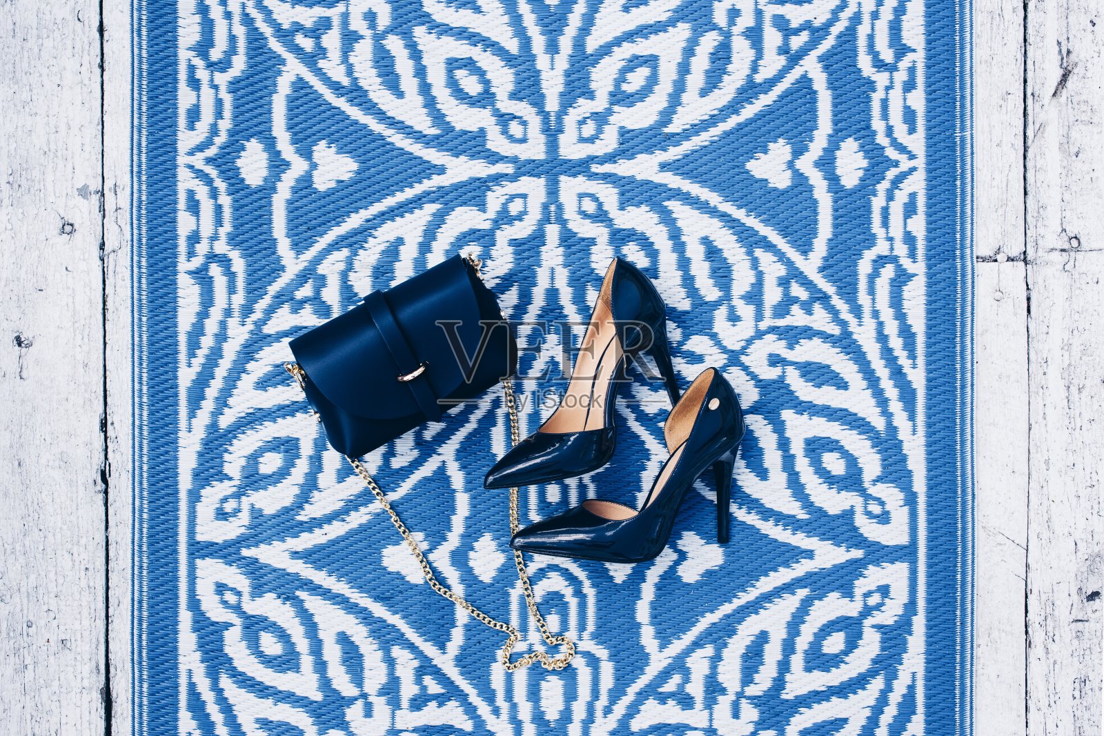 优雅的皮革经典女士蓝色鞋子和时尚的皮革蓝色女士手袋搭配金色皮带创意的蓝色地毯和白色木地板。时尚形象的时尚蓝色女性的夏季高跟鞋。照片摄影图片