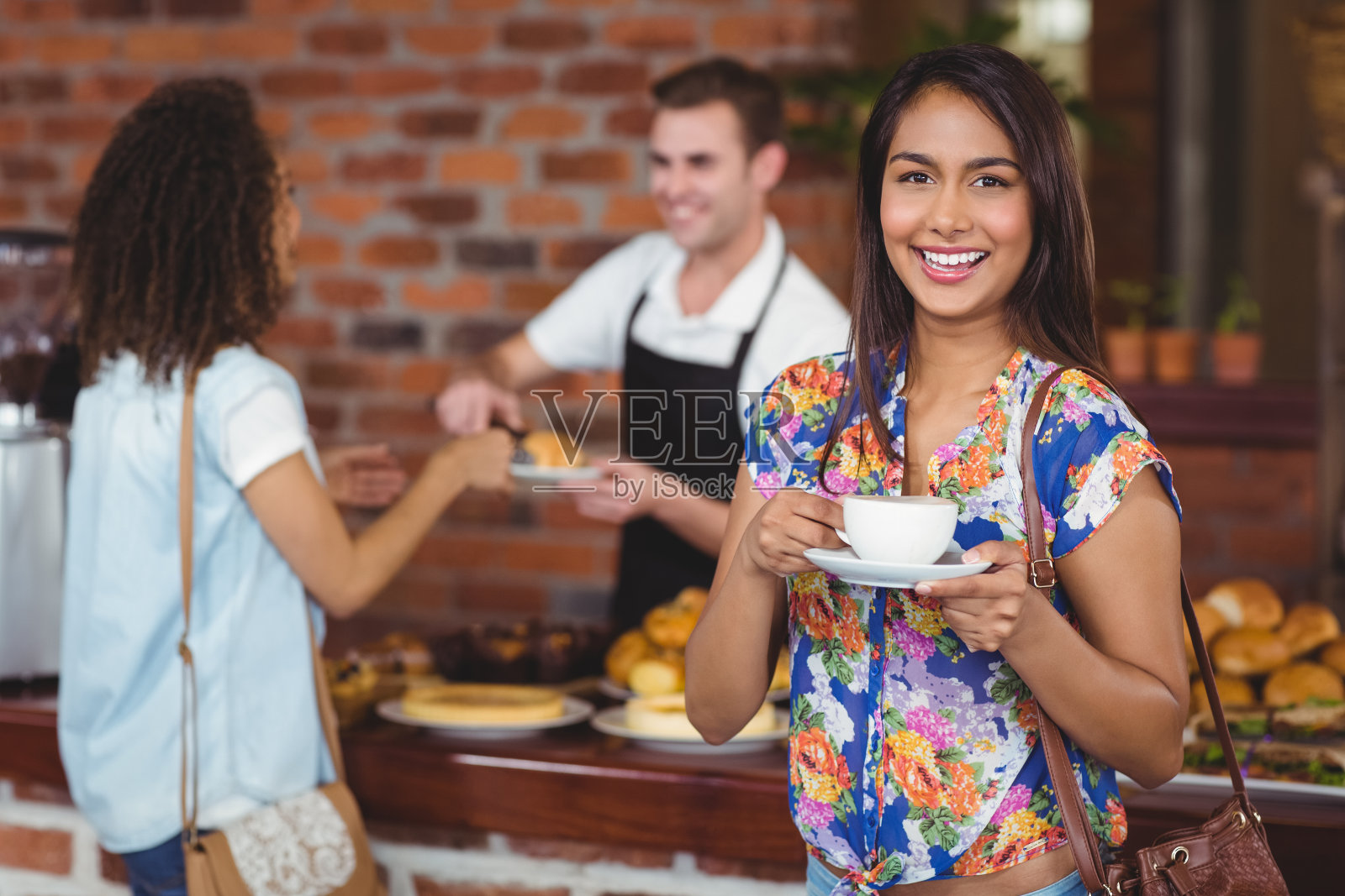 微笑漂亮的顾客拿着一杯咖啡照片摄影图片