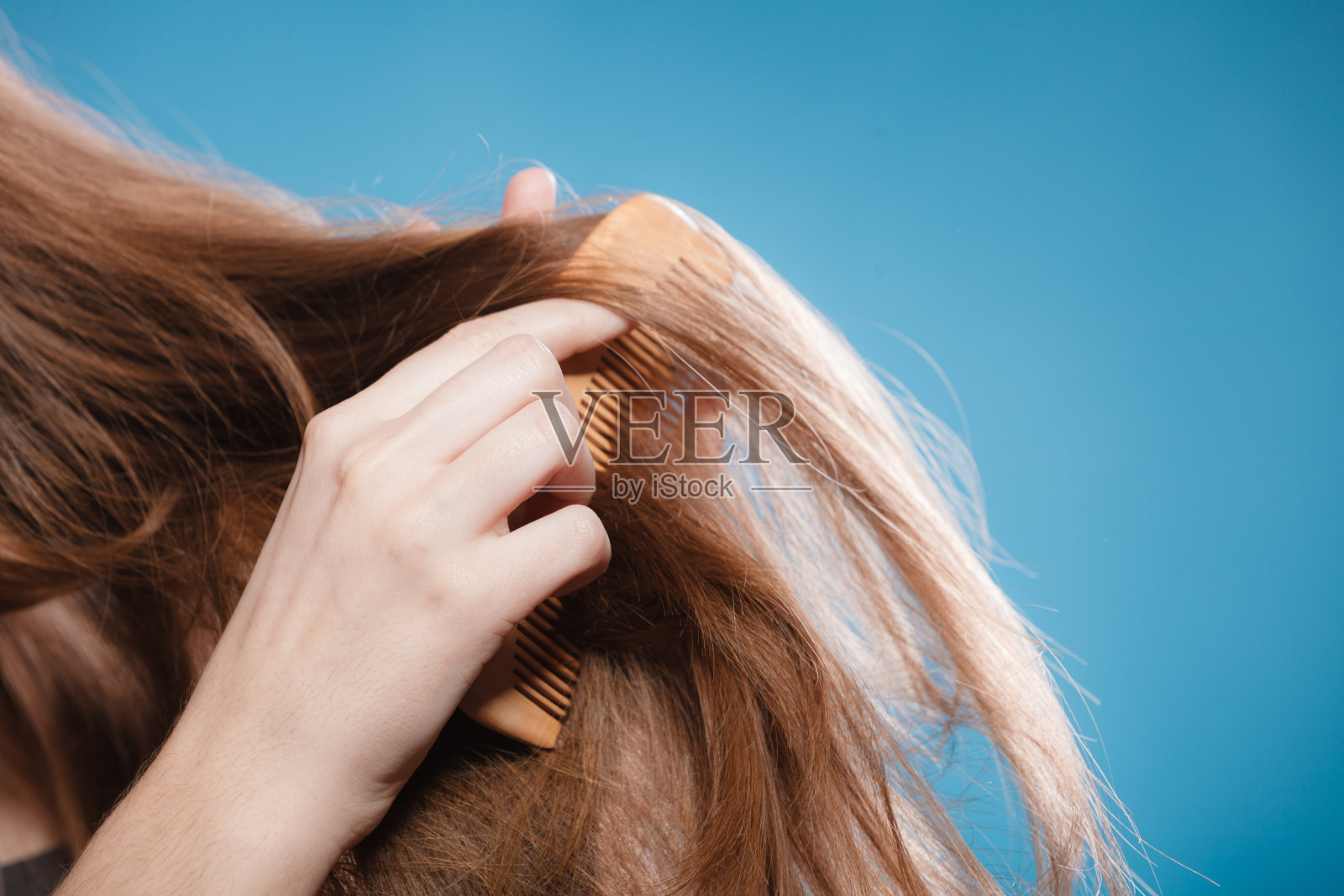 女性用手用木梳梳头发照片摄影图片