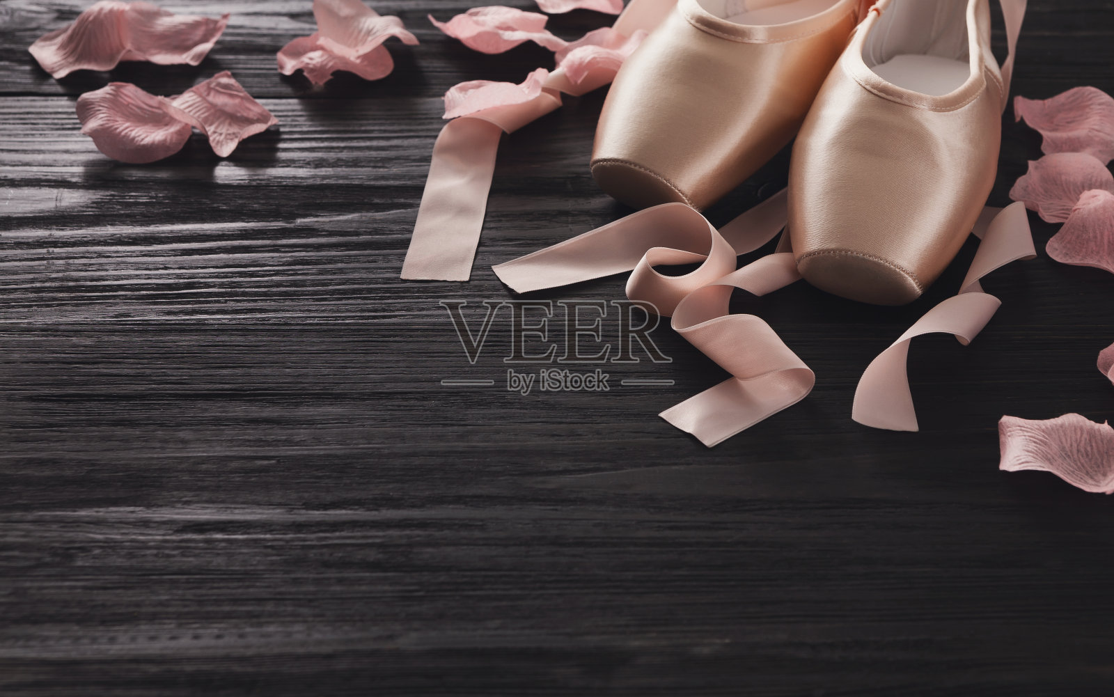 粉红色芭蕾舞尖头鞋上的黑色木材背景照片摄影图片