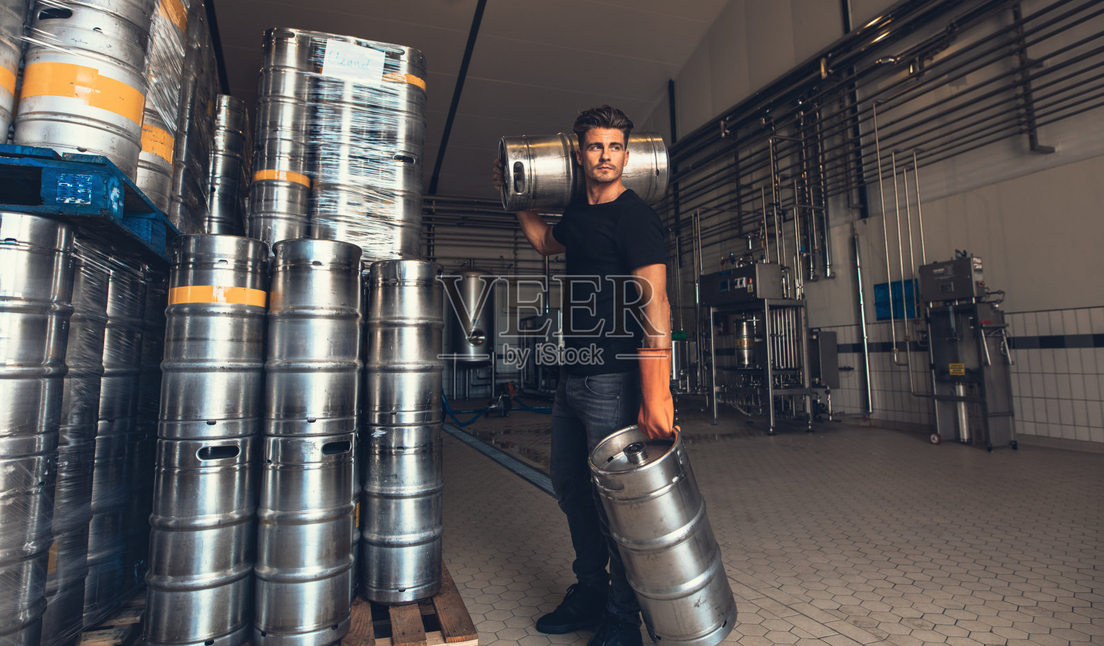 酿酒工在啤酒厂搬运酒桶照片摄影图片