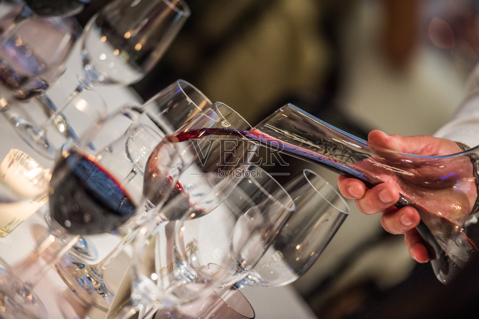 侍酒师将葡萄酒从混合碗倒入玻璃杯，豪华餐厅照片摄影图片