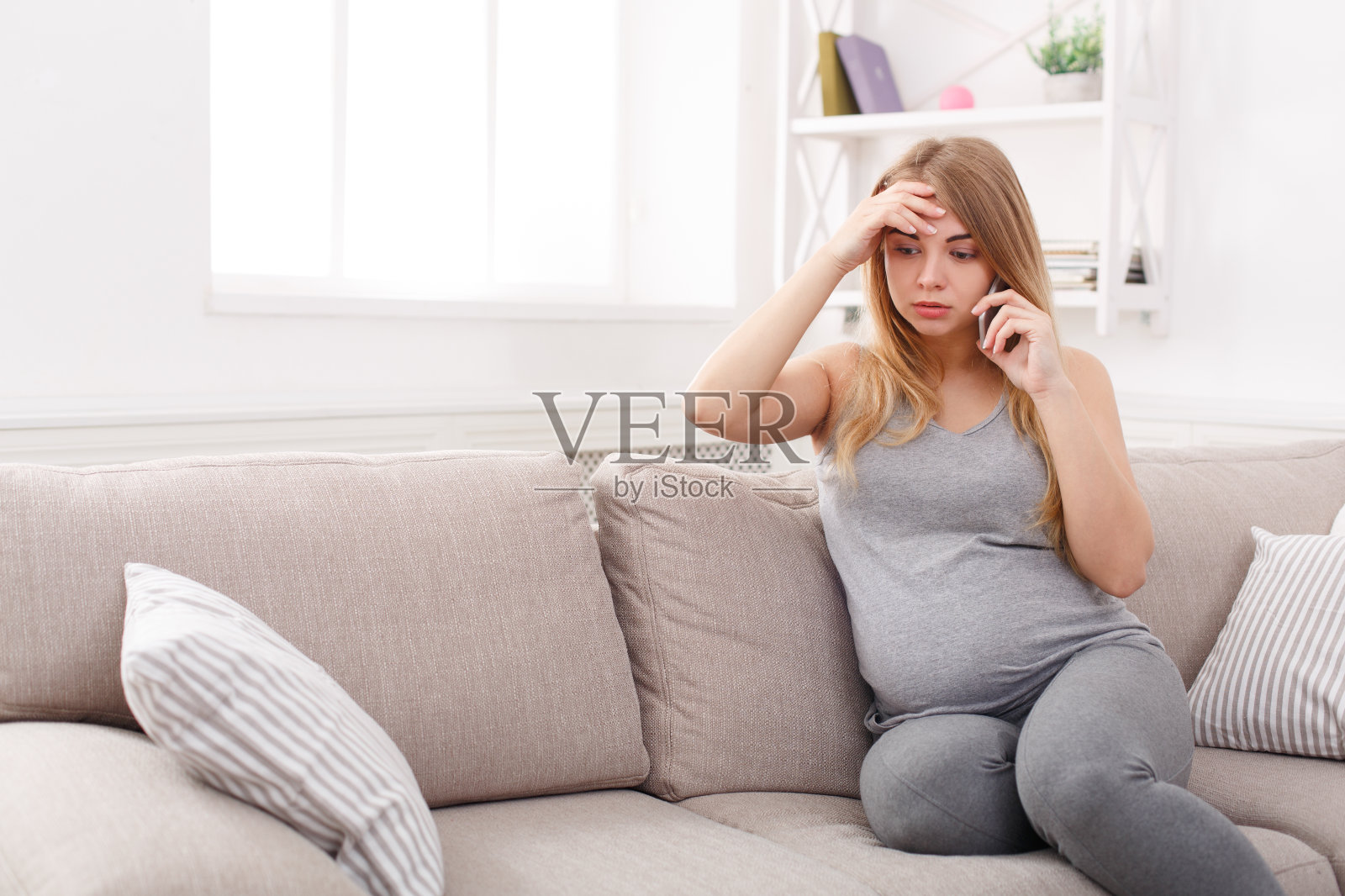 忧心忡忡的孕妇在电话里聊天照片摄影图片