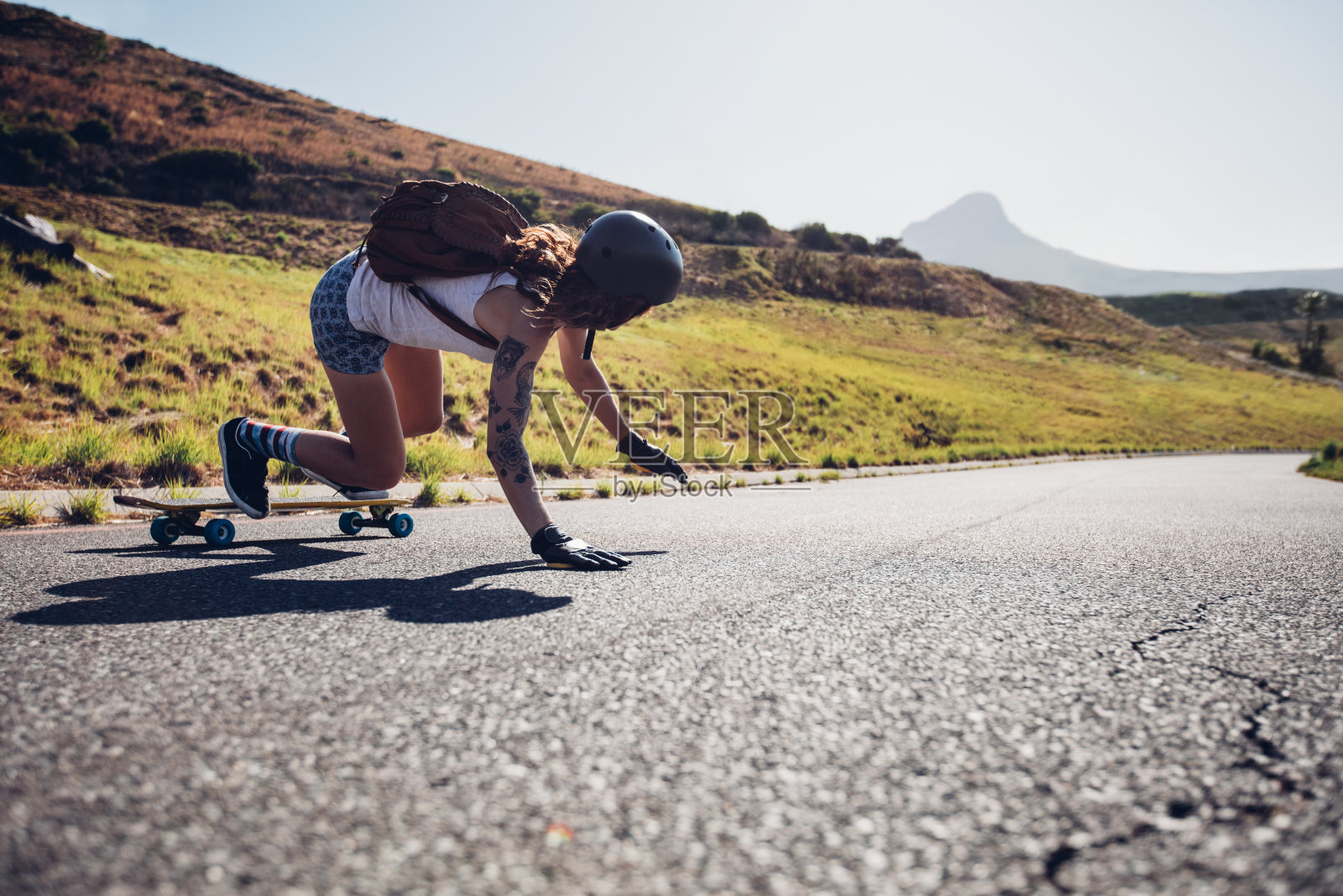 年轻女子在乡村道路上练习滑板照片摄影图片