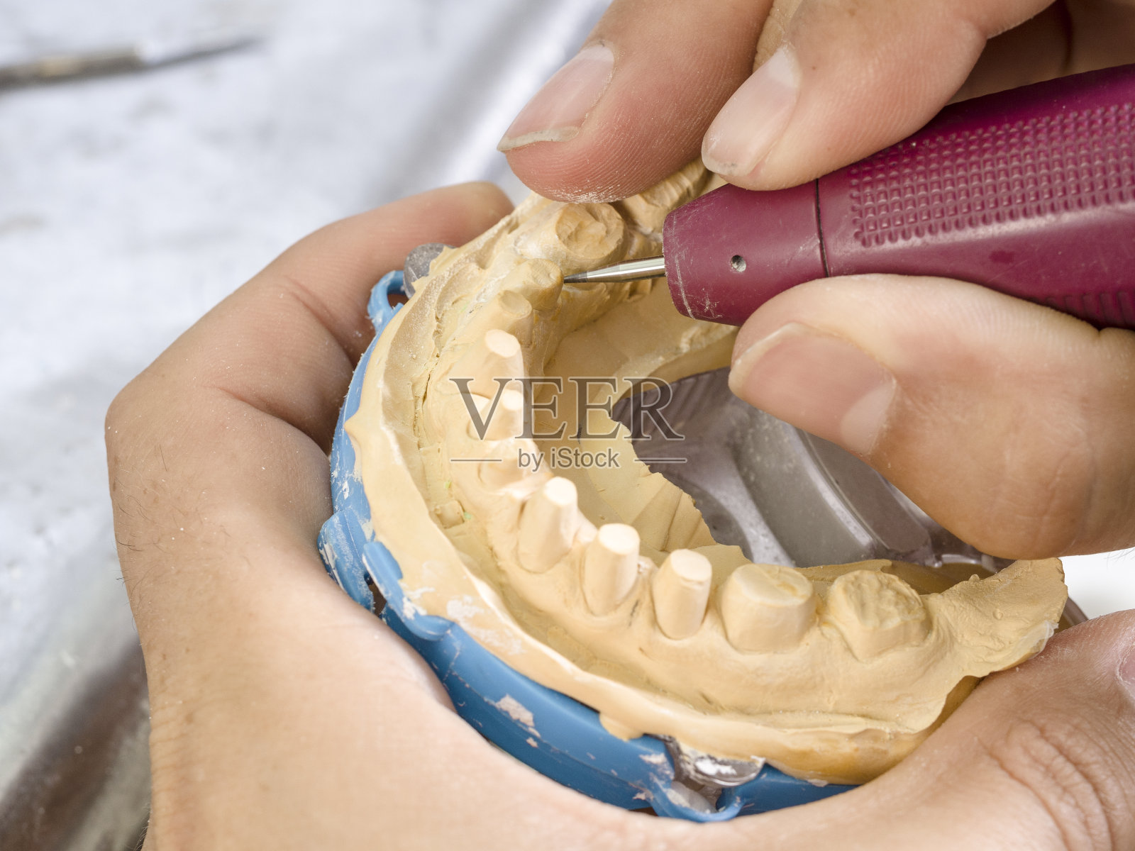 牙科技师用钻头模拟种植陶瓷牙照片摄影图片