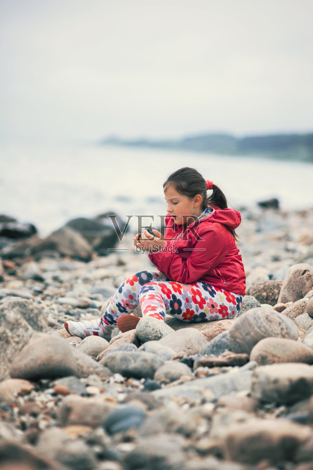 小女孩在海滩上享受和玩石头照片摄影图片