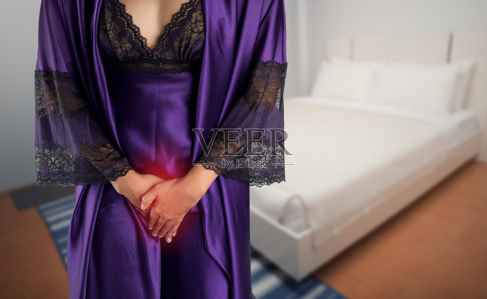 穿紫色缎子睡衣和睡袍的女人起床去洗手间。有膀胱问题的人的概念照片摄影图片