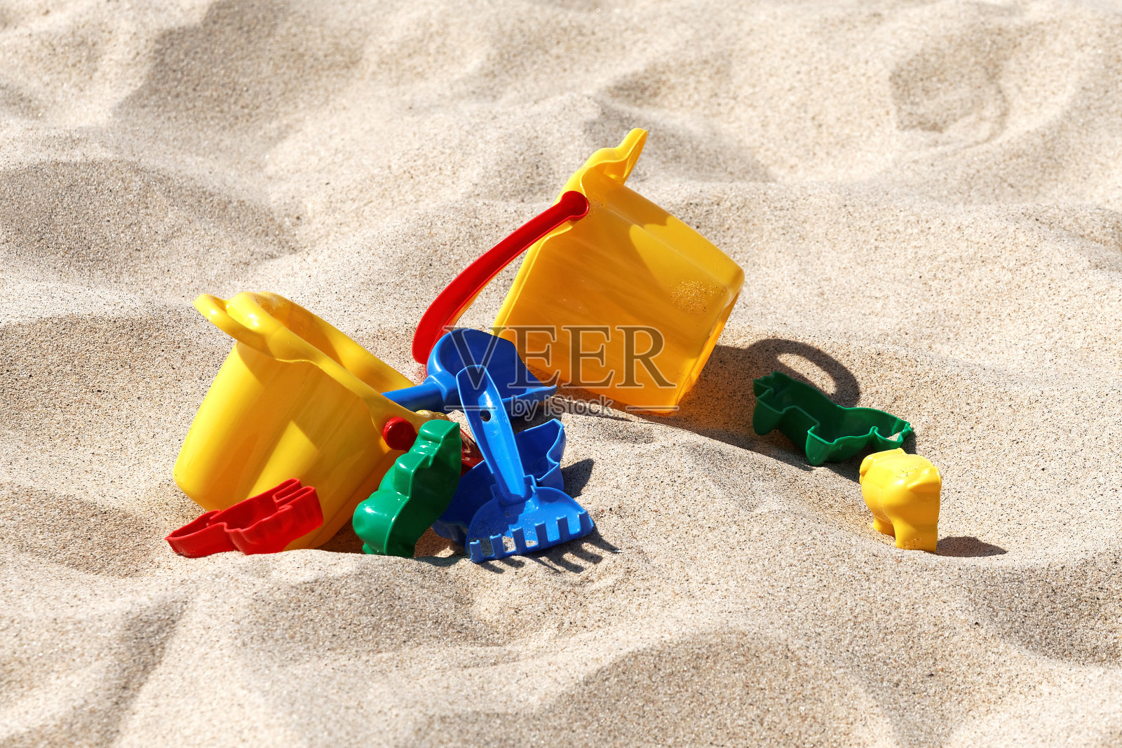 塑料彩色玩具在沙子里照片摄影图片