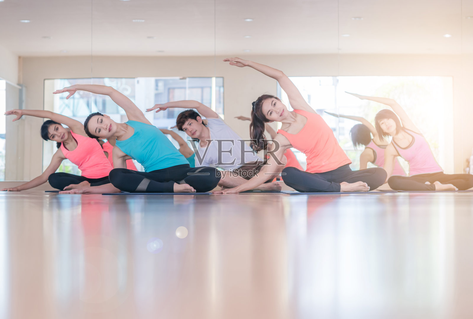 在健身中心做伸展训练的亚洲女性。年轻苗条的女孩做有氧运动。瑜伽练习练习课概念照片摄影图片