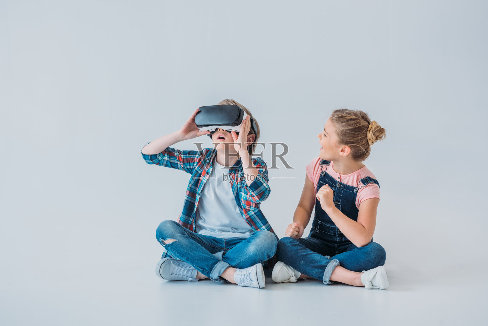 可爱的孩子坐在地板上使用虚拟现实耳机照片摄影图片