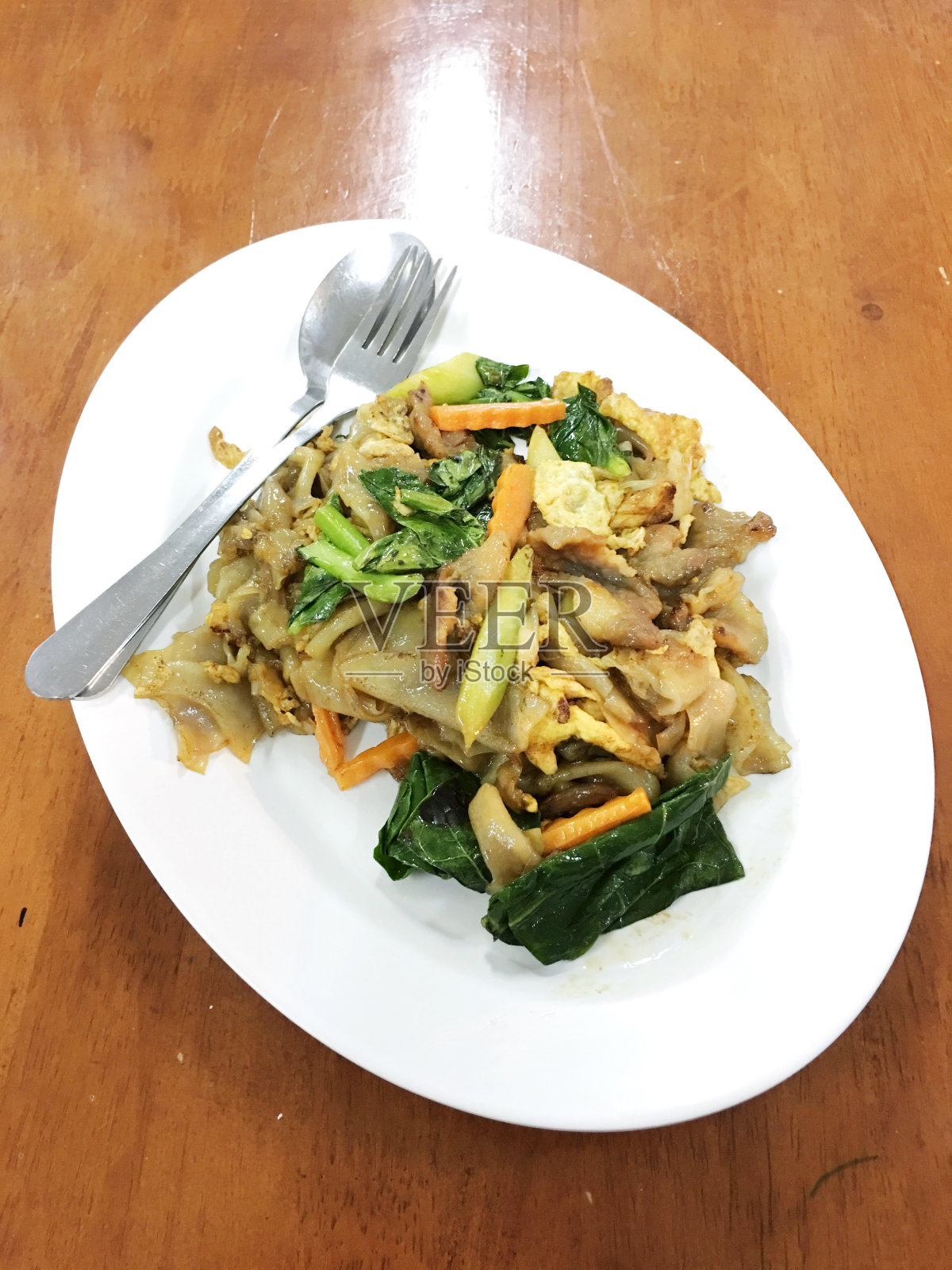 木桌上白底豆沙炒面和猪肉。泰国风格的食物。照片摄影图片