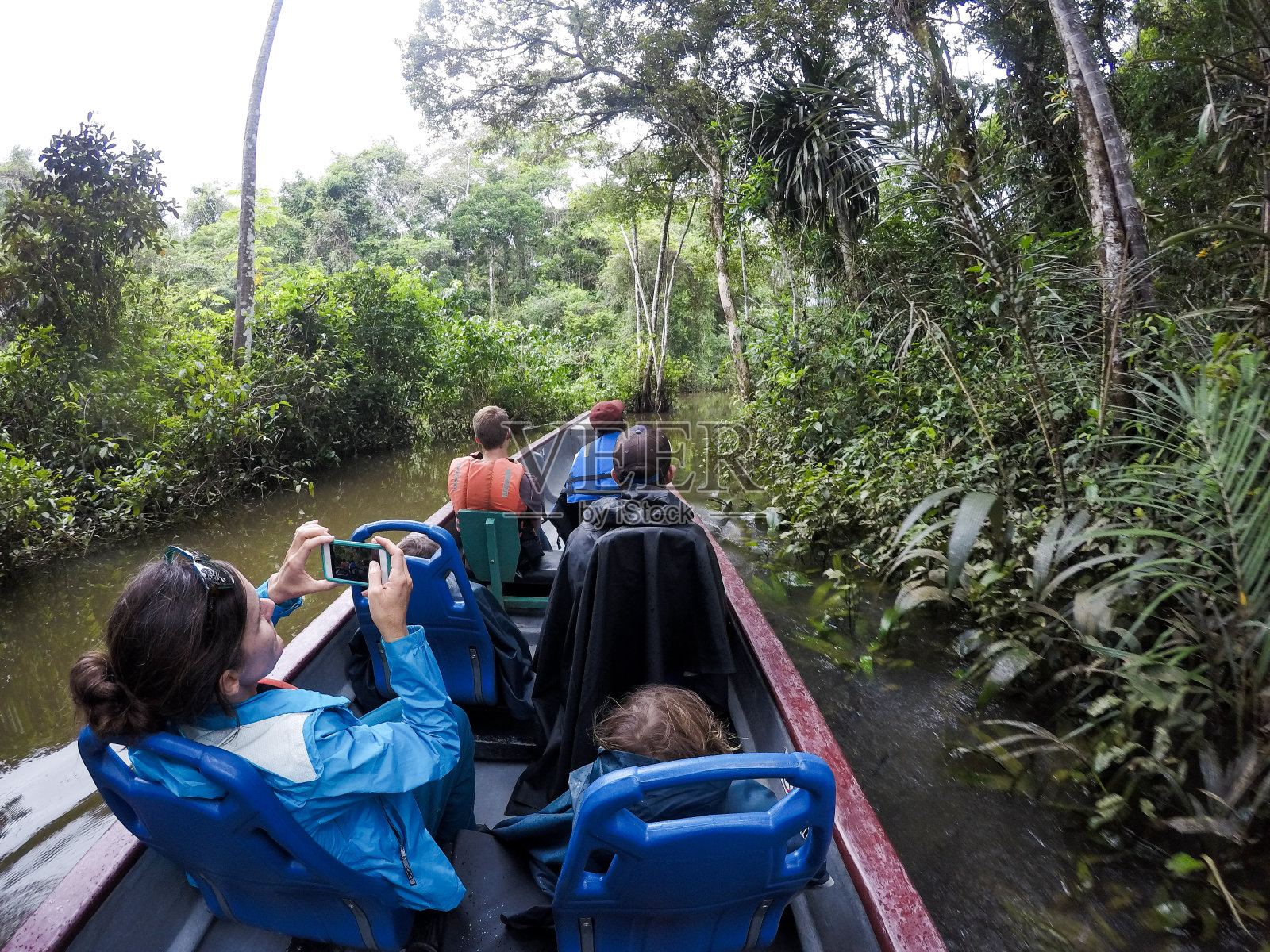 一家人坐船穿越亚马逊丛林照片摄影图片