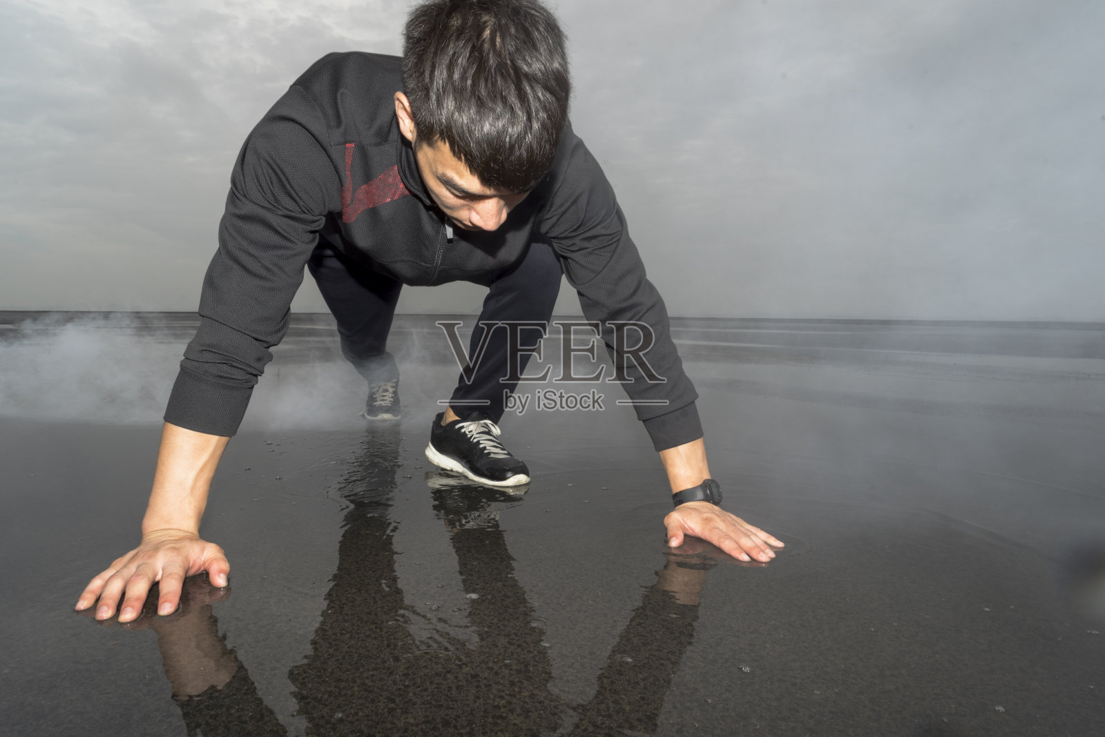男性跑步者在起跑位置与水池反射照片摄影图片