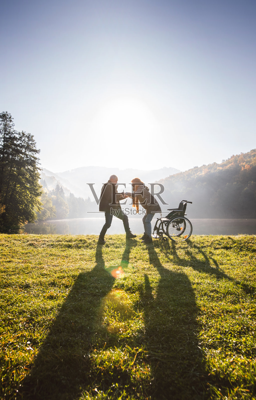 老年夫妇与轮椅在秋天的自然。照片摄影图片