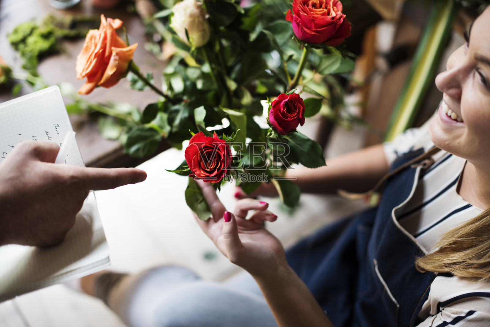 花商拿着一束玫瑰。照片摄影图片