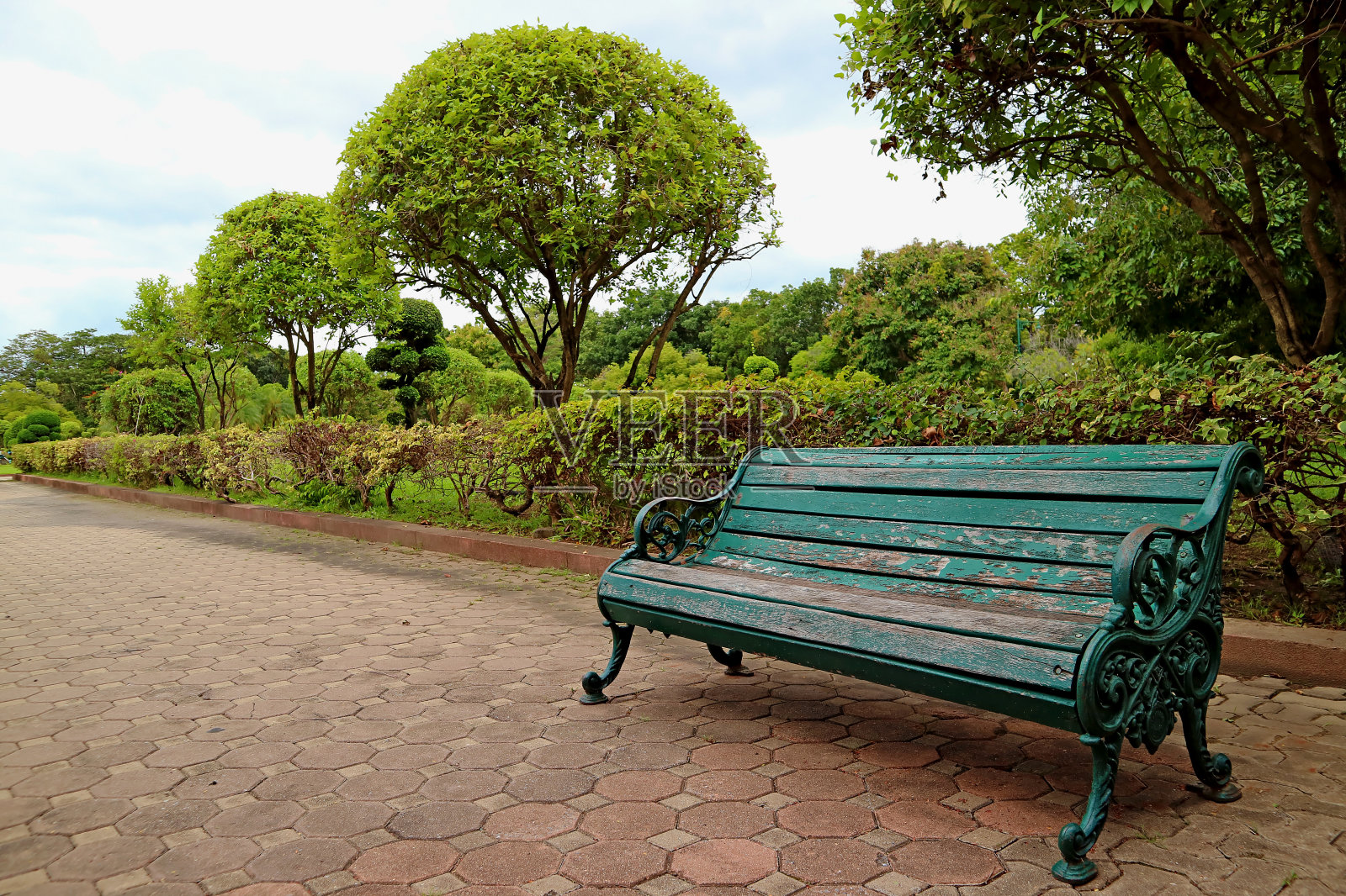 泰国公园小径上的绿色木材和锻铁长凳照片摄影图片