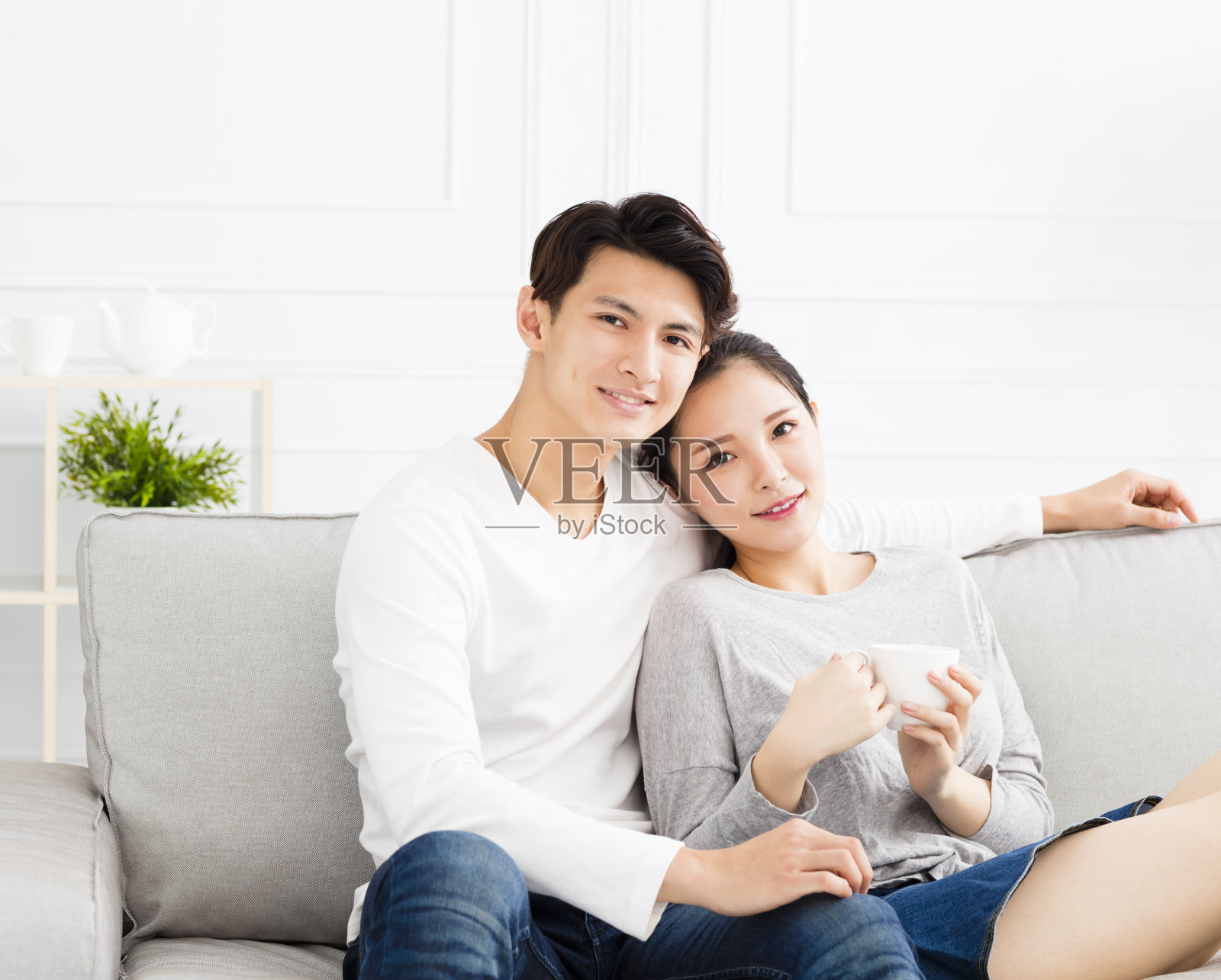 放松的年轻亚洲夫妇在沙发上照片摄影图片