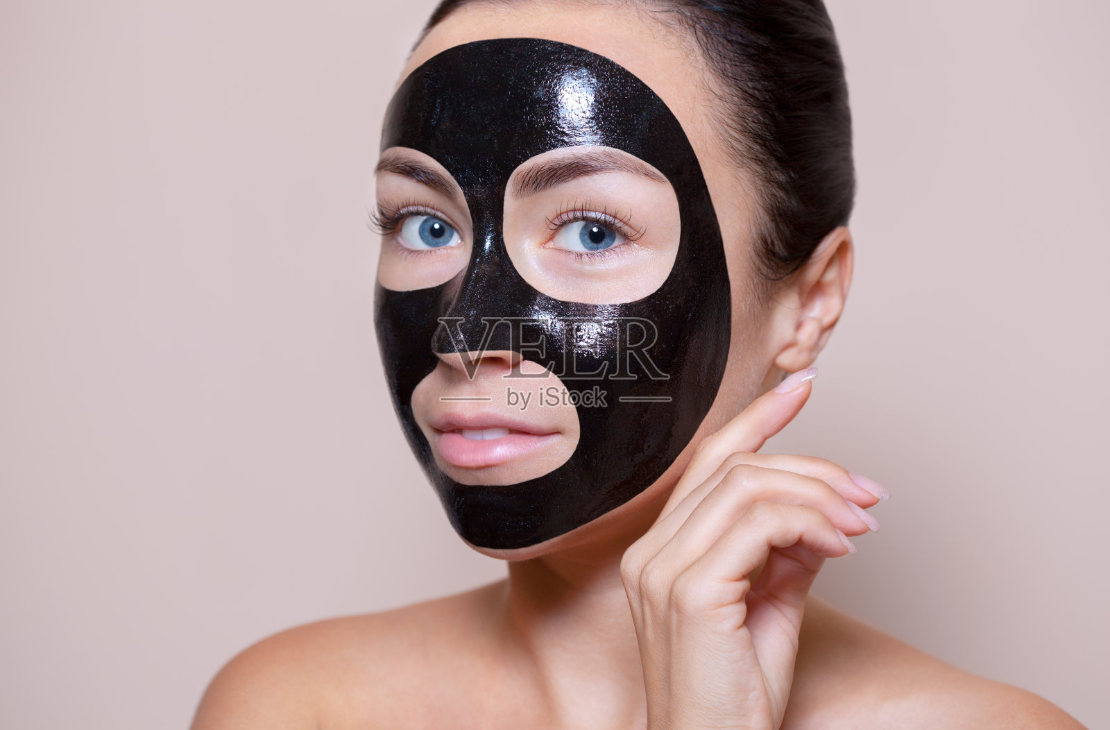 一个漂亮女人脸上的黑色面具。照片摄影图片