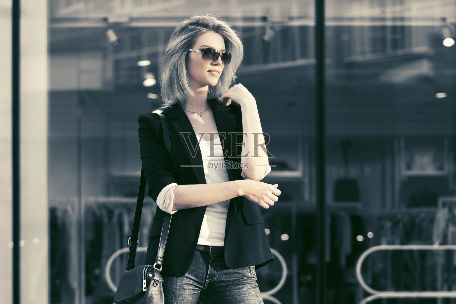 年轻时尚的金发女商人戴着太阳镜在购物中心照片摄影图片