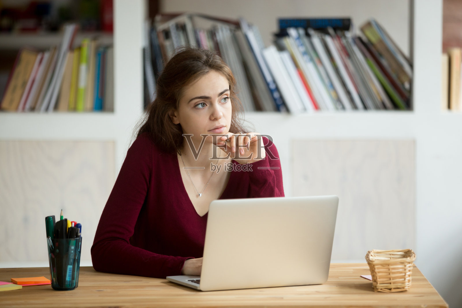 有思想的年轻女企业家坐在笔记本电脑前。照片摄影图片
