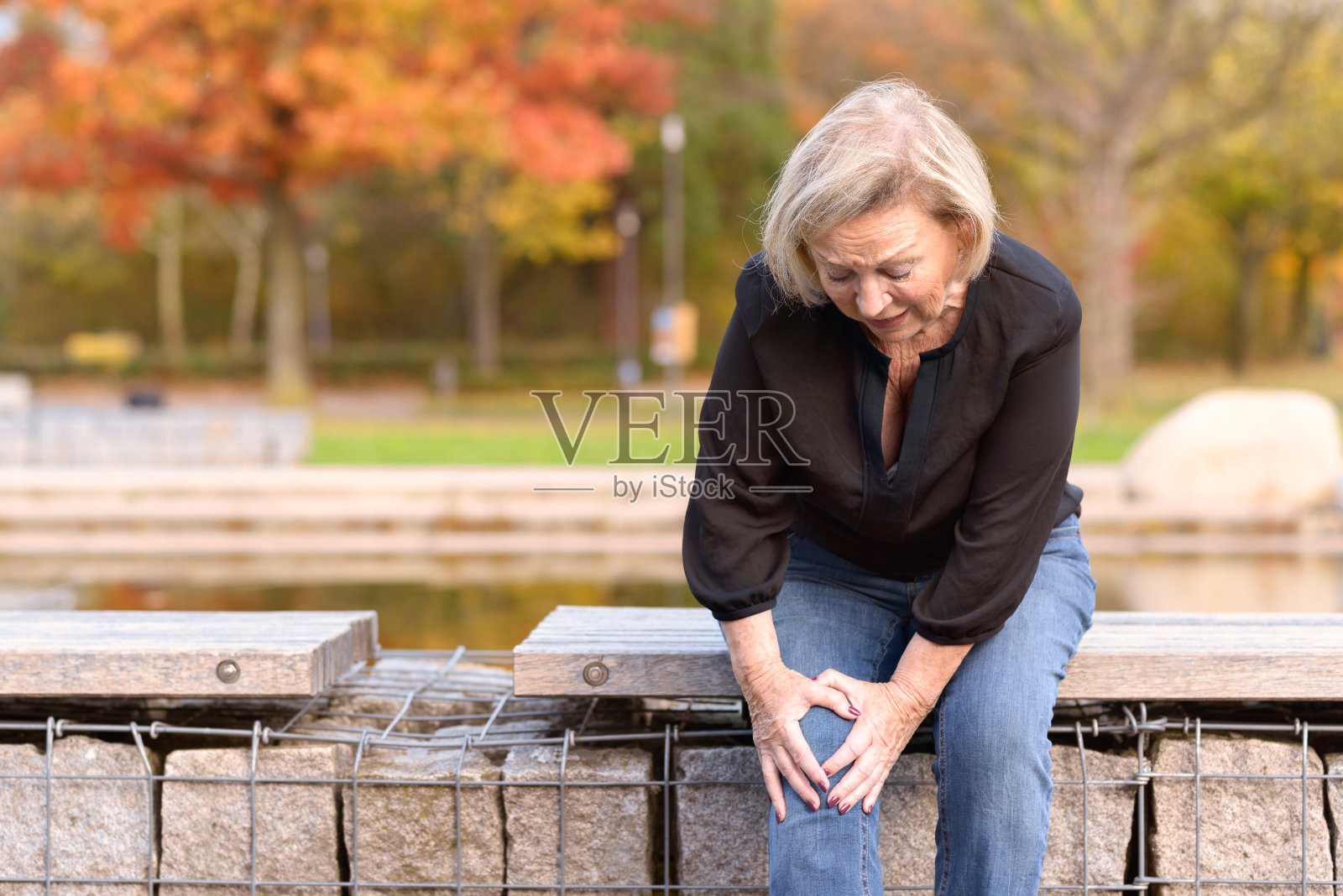 老妇人痛苦地抱住膝盖照片摄影图片