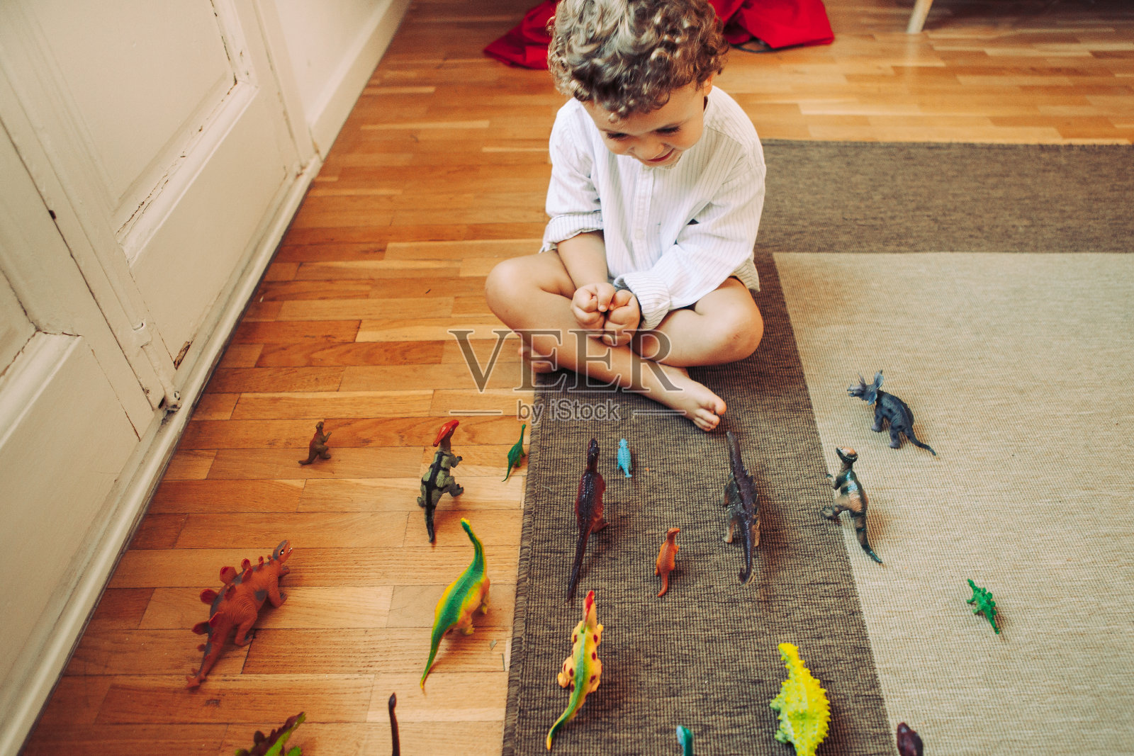 男孩在玩玩具恐龙照片摄影图片