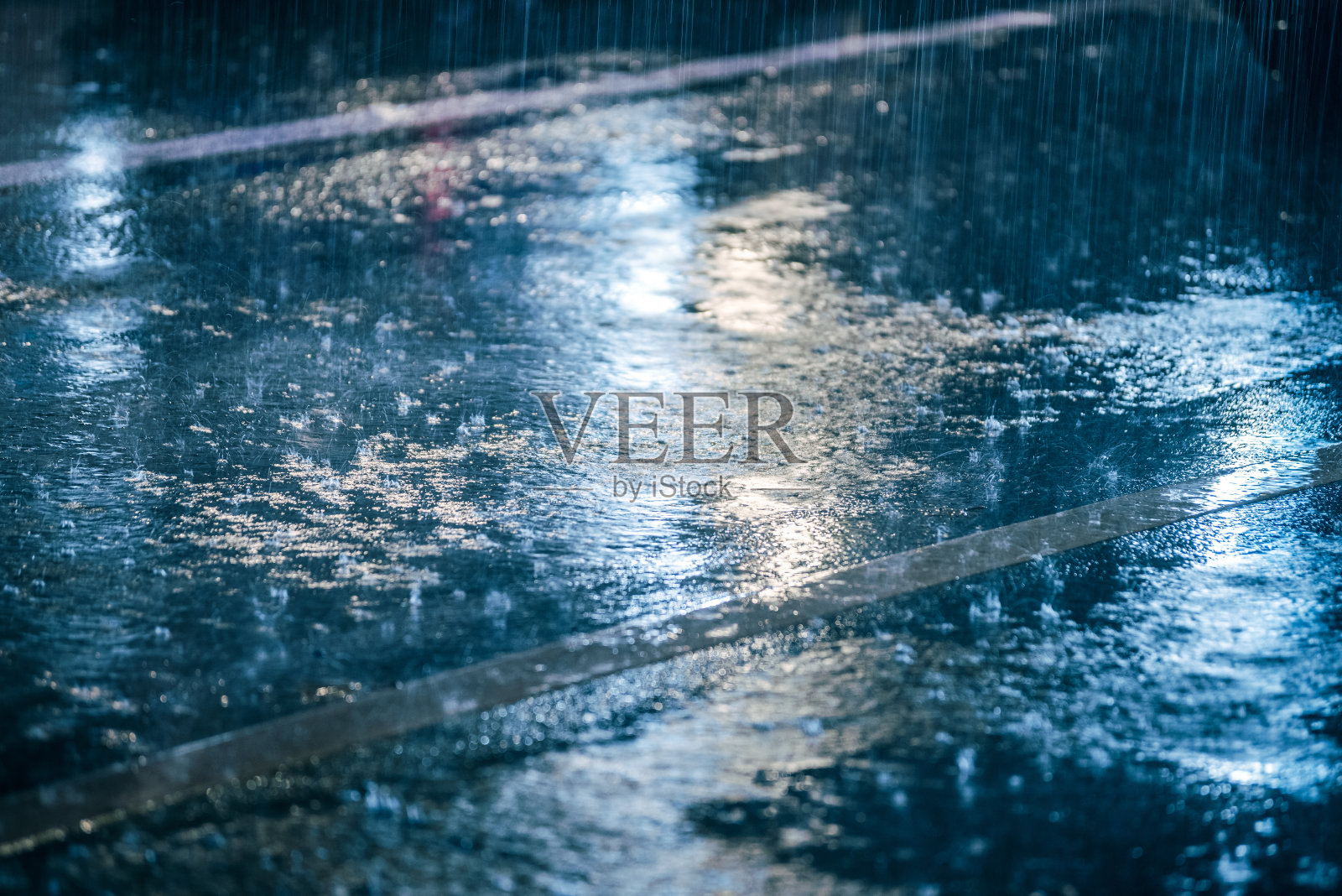 五颜六色的灯光在雨中潮湿的沥青上反射照片摄影图片