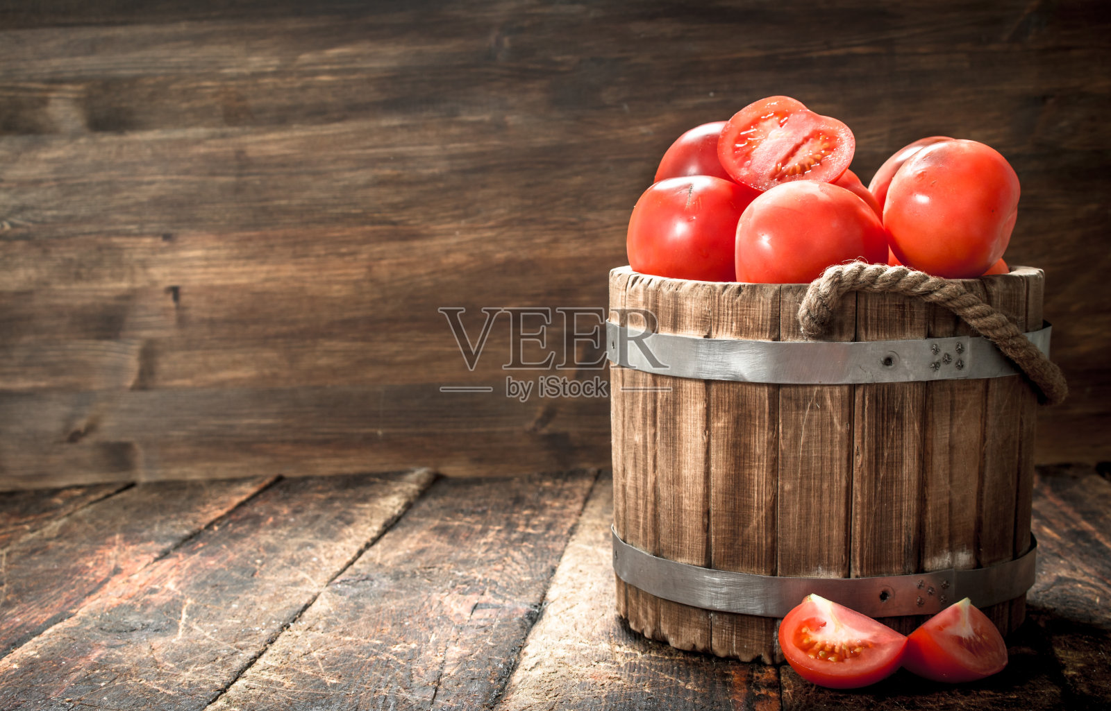 木桶里的新鲜西红柿。照片摄影图片