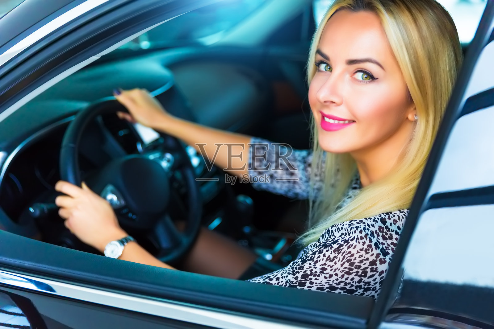 快乐的年轻女子坐在现代豪华轿车里照片摄影图片