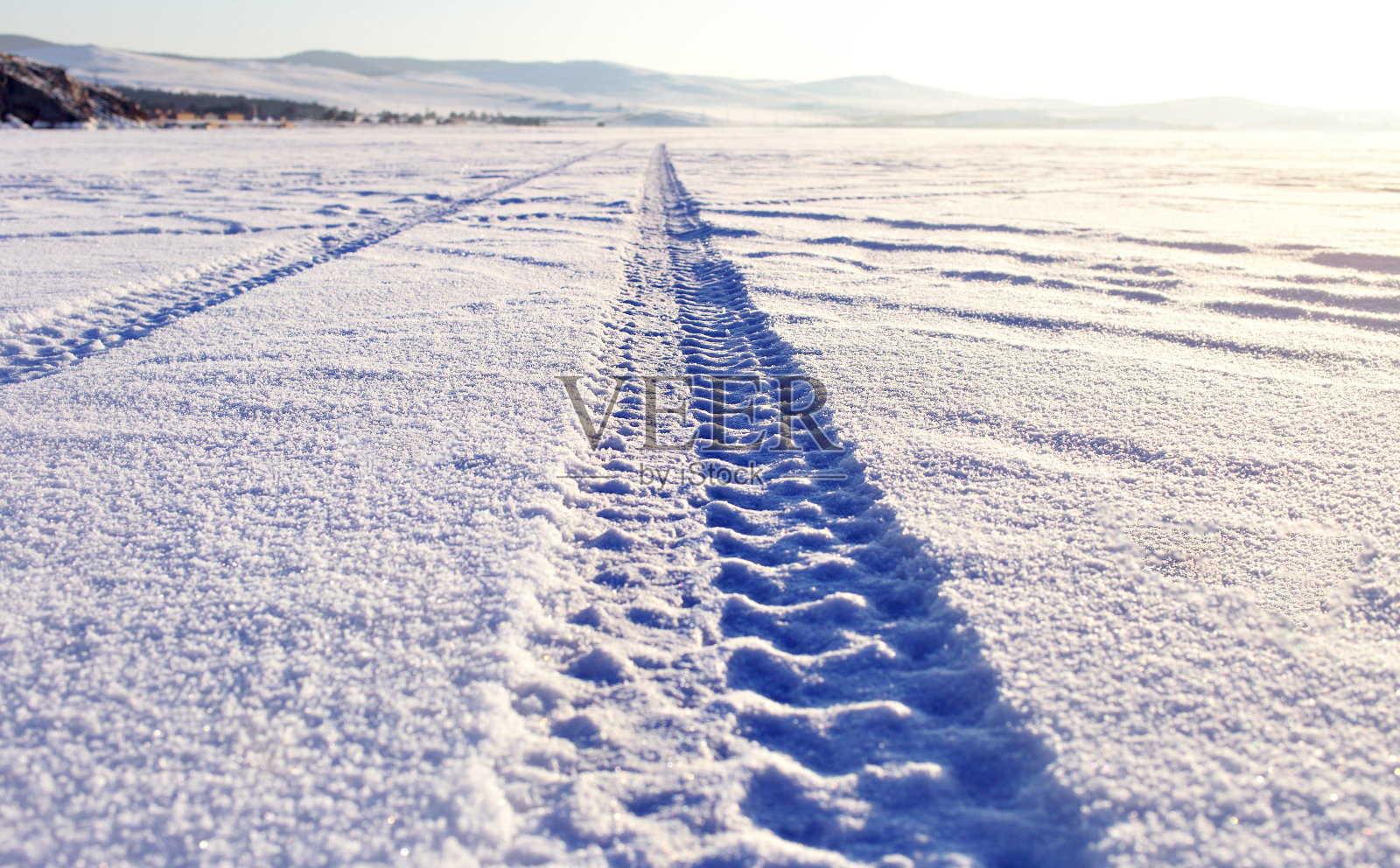 贝加尔湖冰面上的雪地上留下了轮胎的痕迹照片摄影图片
