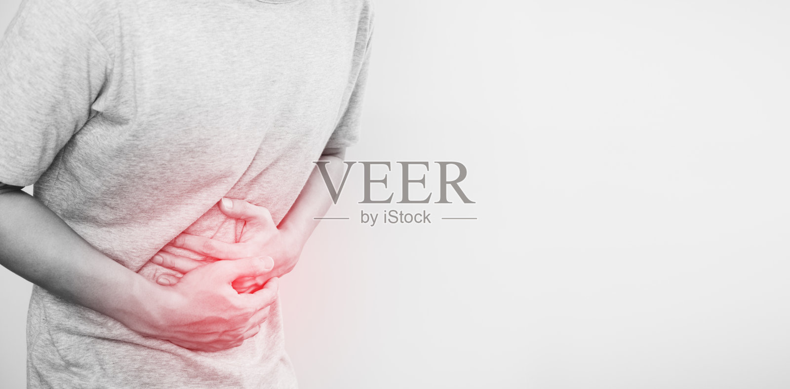 一个男人摸着自己的肚子，红色突出胃部疼痛和其他胃部疾病的概念，在白色背景上用空格复制照片摄影图片