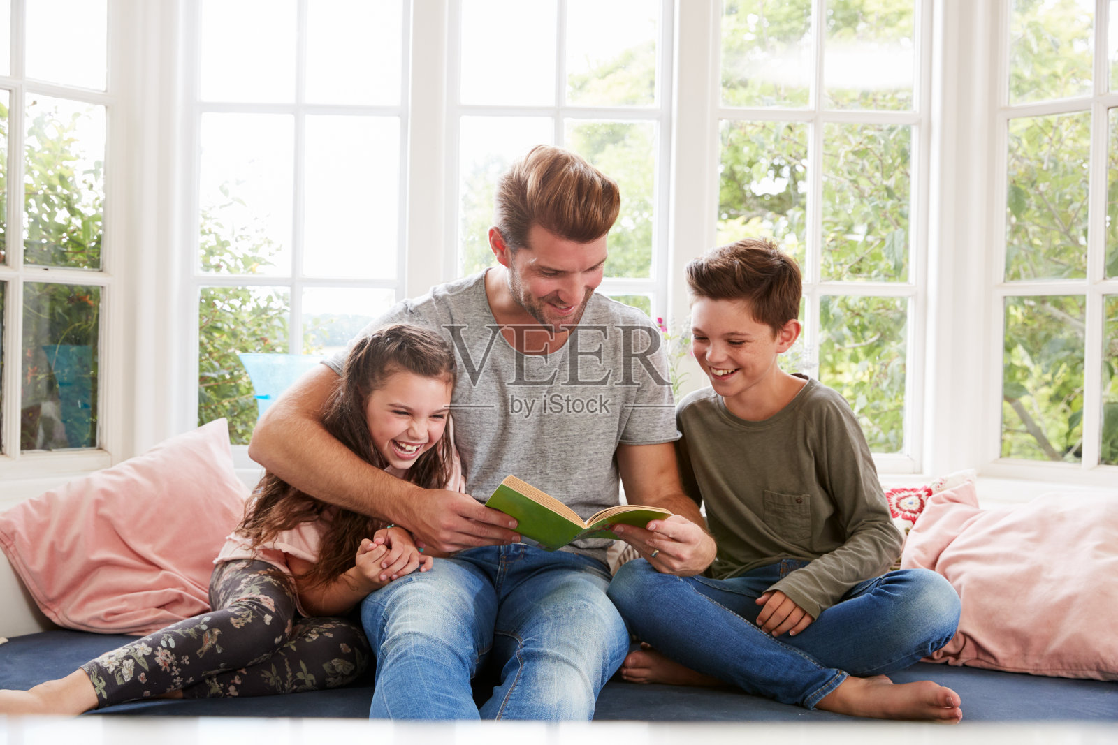父亲和儿子女儿在家里读书照片摄影图片