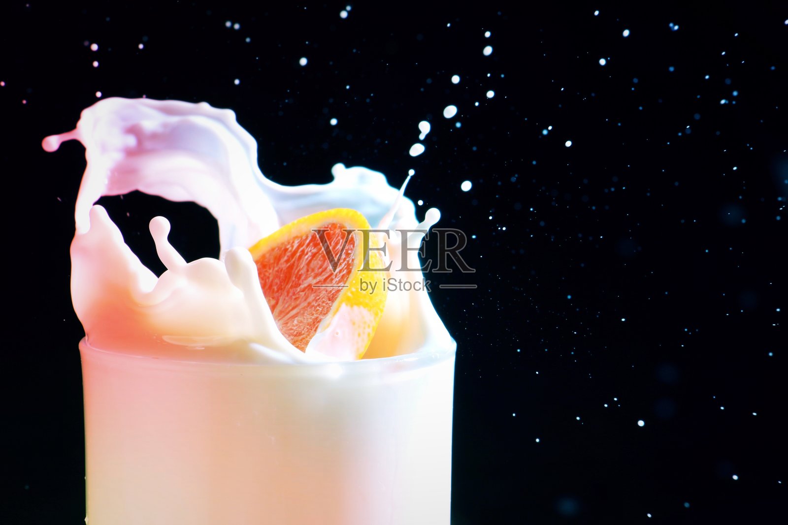 一片葡萄柚滴在一杯牛奶里照片摄影图片