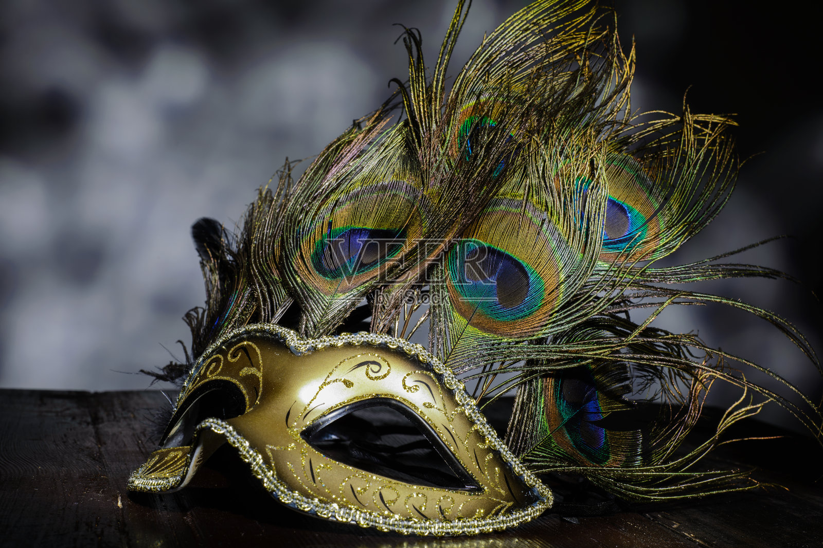威尼斯狂欢节面具孔雀羽毛在黑暗的背景照片摄影图片