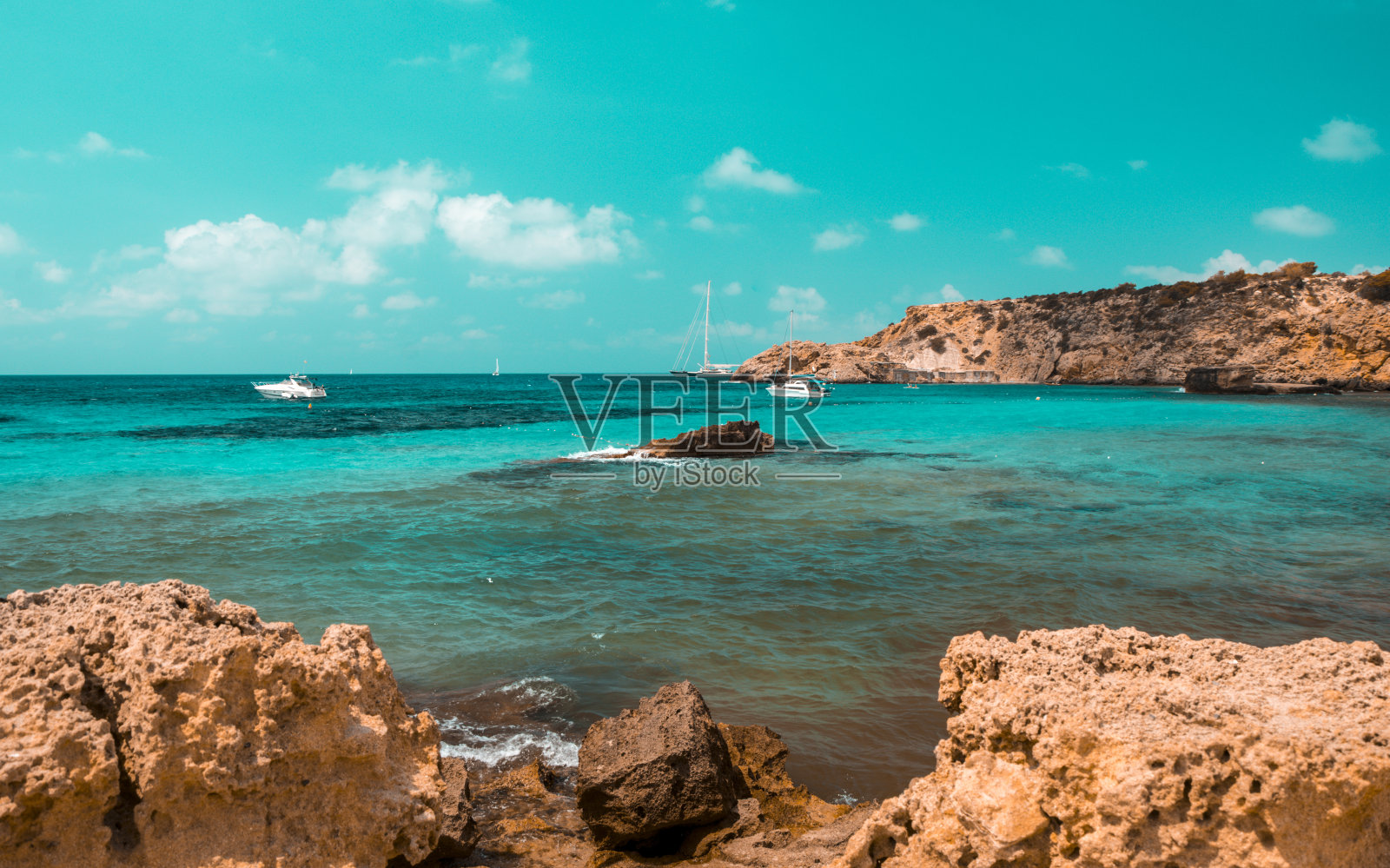 蓝绿色和橙色的卡拉塔里达海滩与石头，伊比沙岛。西班牙照片摄影图片