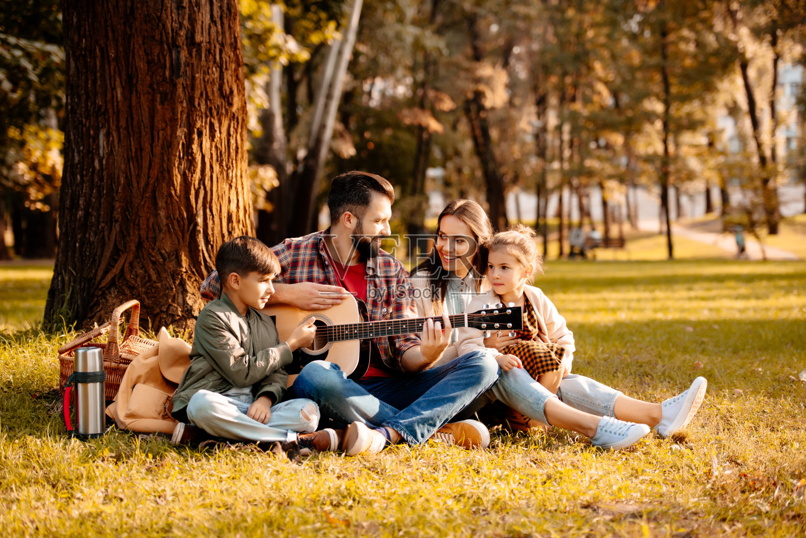 一家人在野餐时弹吉他照片摄影图片