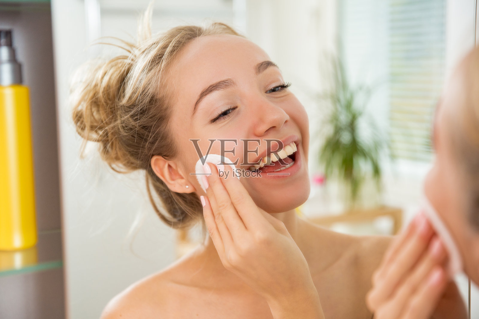 年轻漂亮的女子正在用化妆棉洗脸照片摄影图片