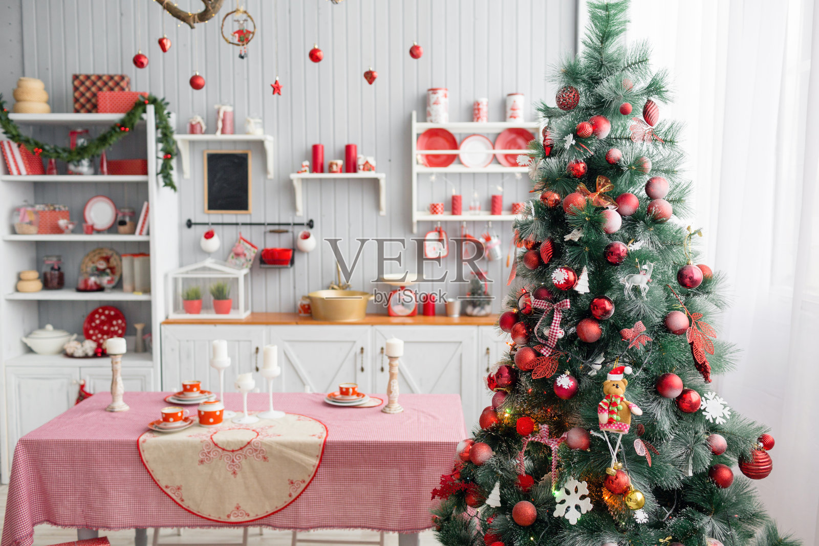 室内浅灰色的厨房和红色的圣诞装饰。用厨房的概念在家准备午餐。专注于树照片摄影图片