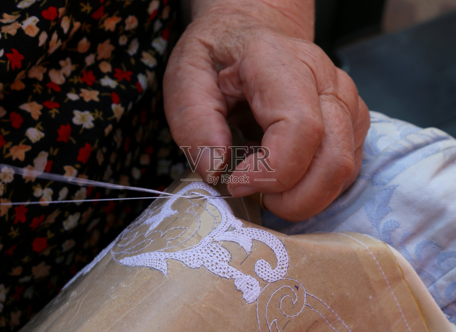 一名老年妇女的手绣着一个花边与tombolo和c照片摄影图片