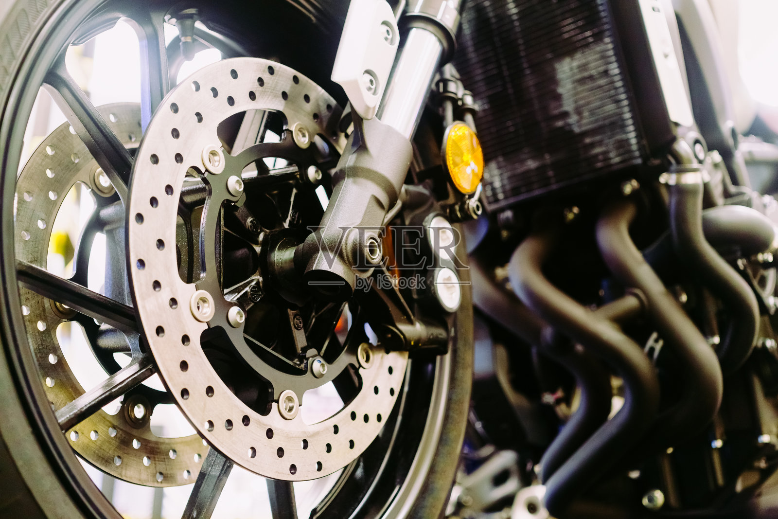 摩托车前轮的悬挂和盘式制动系统的特写。照片摄影图片