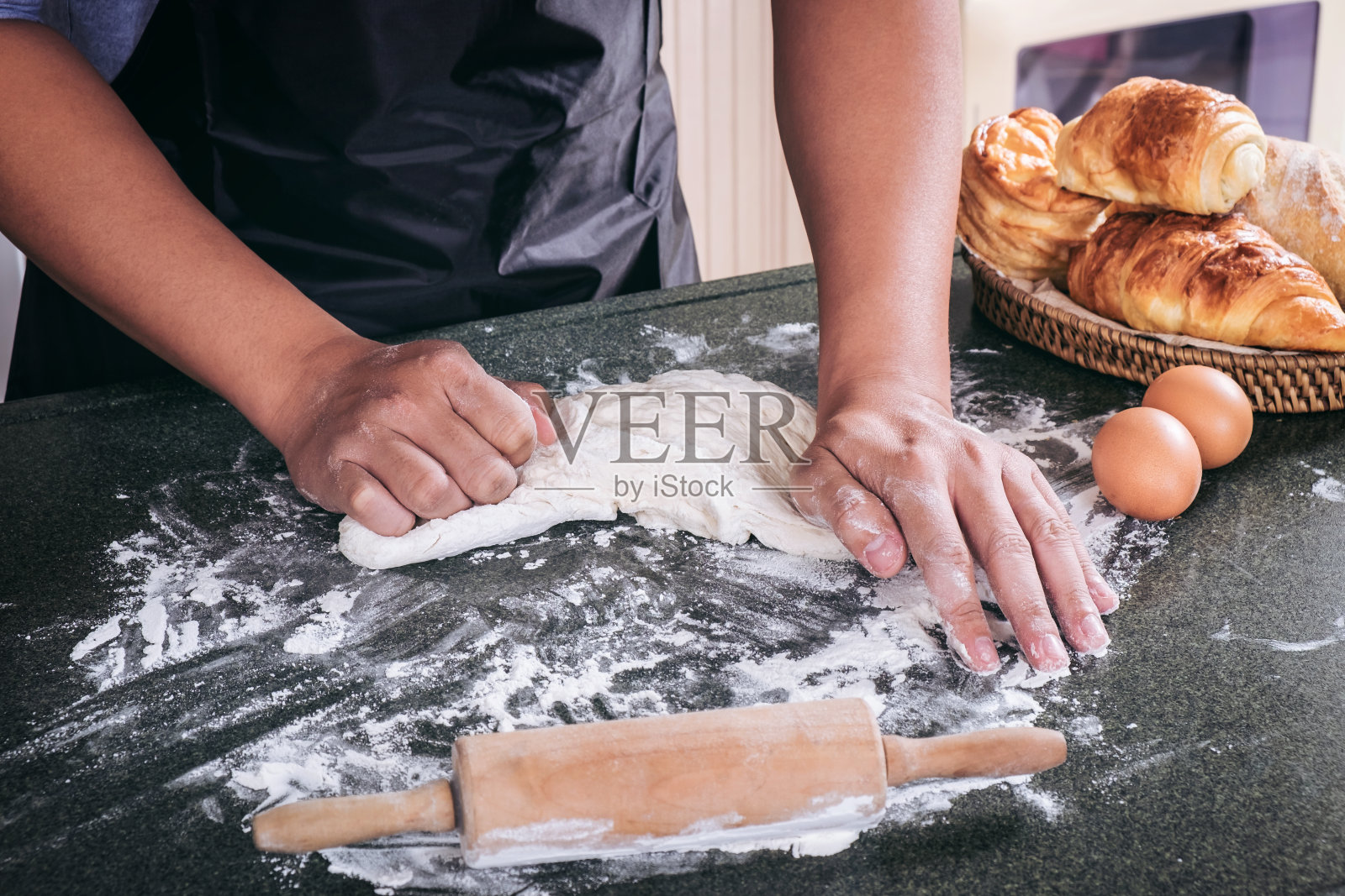 生面团为面包用配料以黑色为背景，揉面时男性用手撒上面粉照片摄影图片