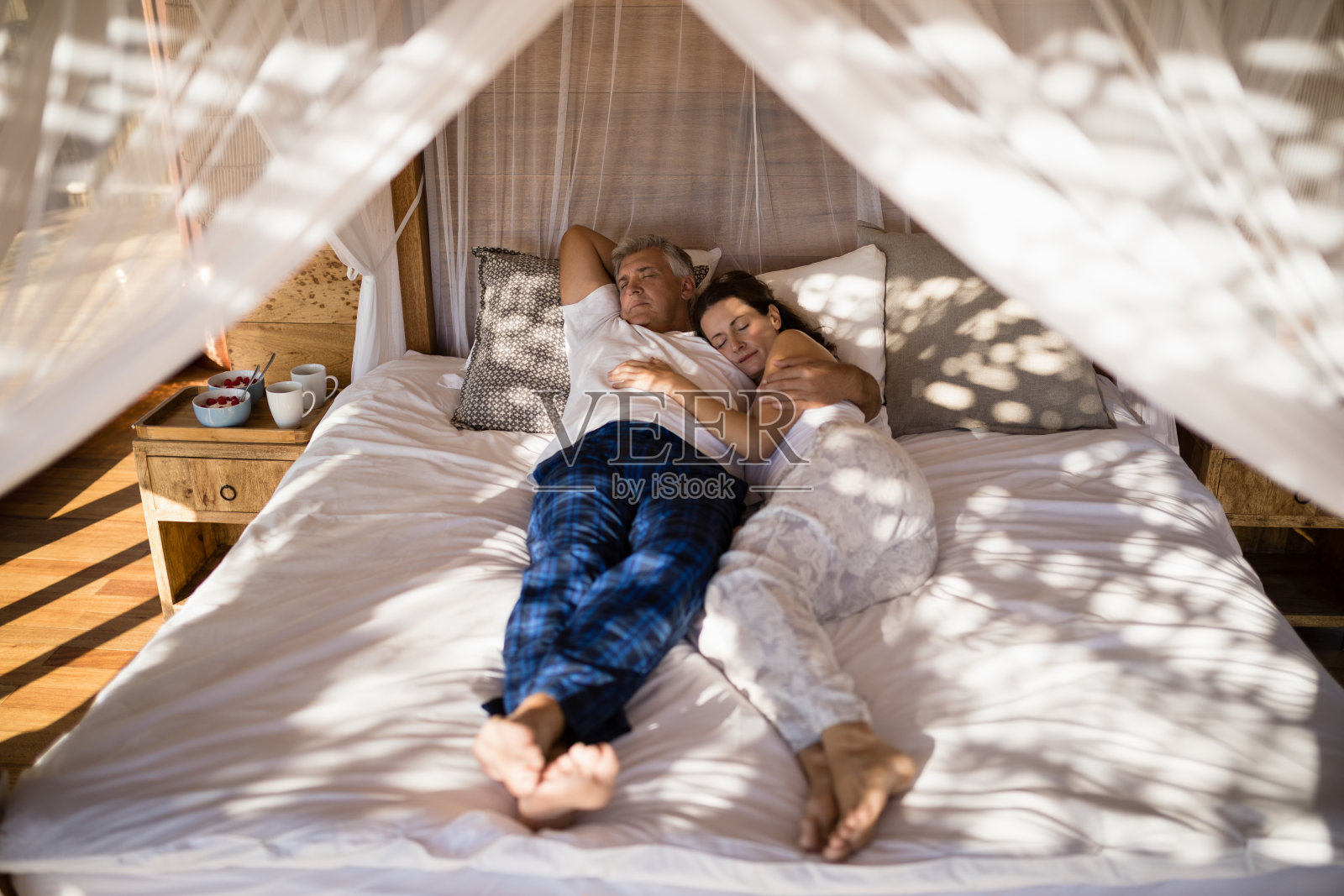 一对夫妇在天篷床上放松照片摄影图片